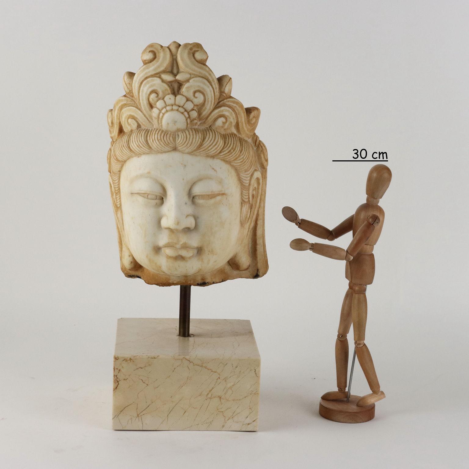 Cabeza de Guanyin de mármol con base de travertino.