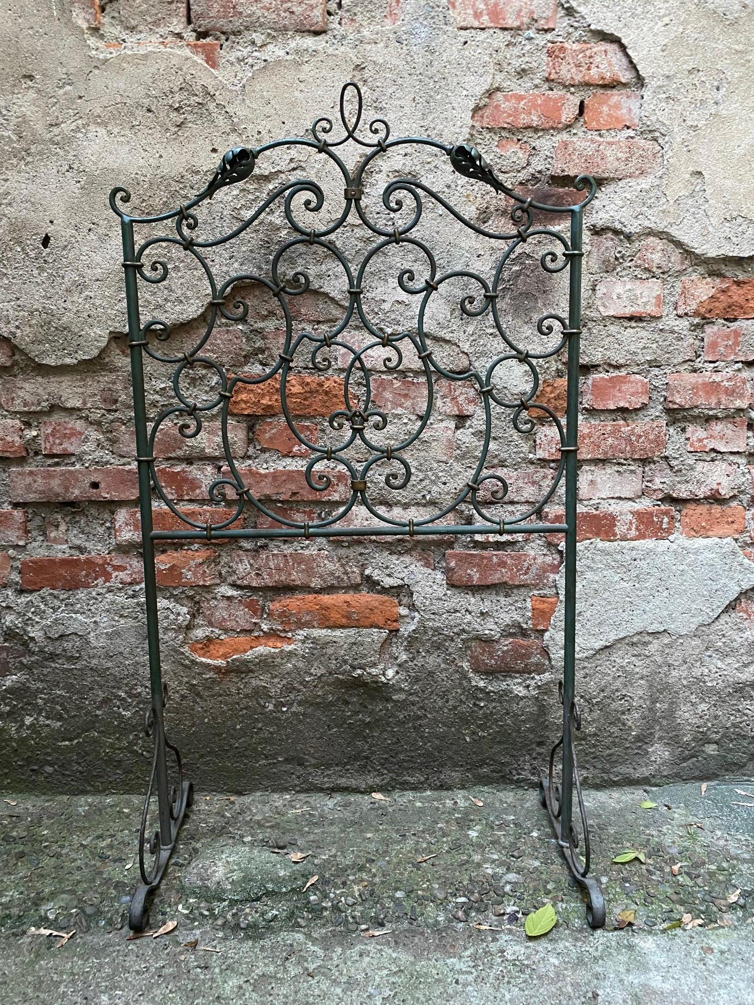 An original wrought iron children's bed headboard handmade in Italy in the early 20th century. It comes from a private collection in Milan and is in good condition, with a delicate lacquer finish in excavated green.

The headboard's curly decoration