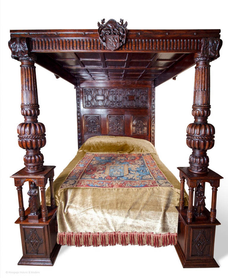 A vintage king size oak tester or four poster bed in the Renaissance style.  Hand carved with Adam & Eve carvings in the headboard, figurative sculptures in the bedposts, three carved armorials on the pelmet rail and an armorial tapestry and velvet