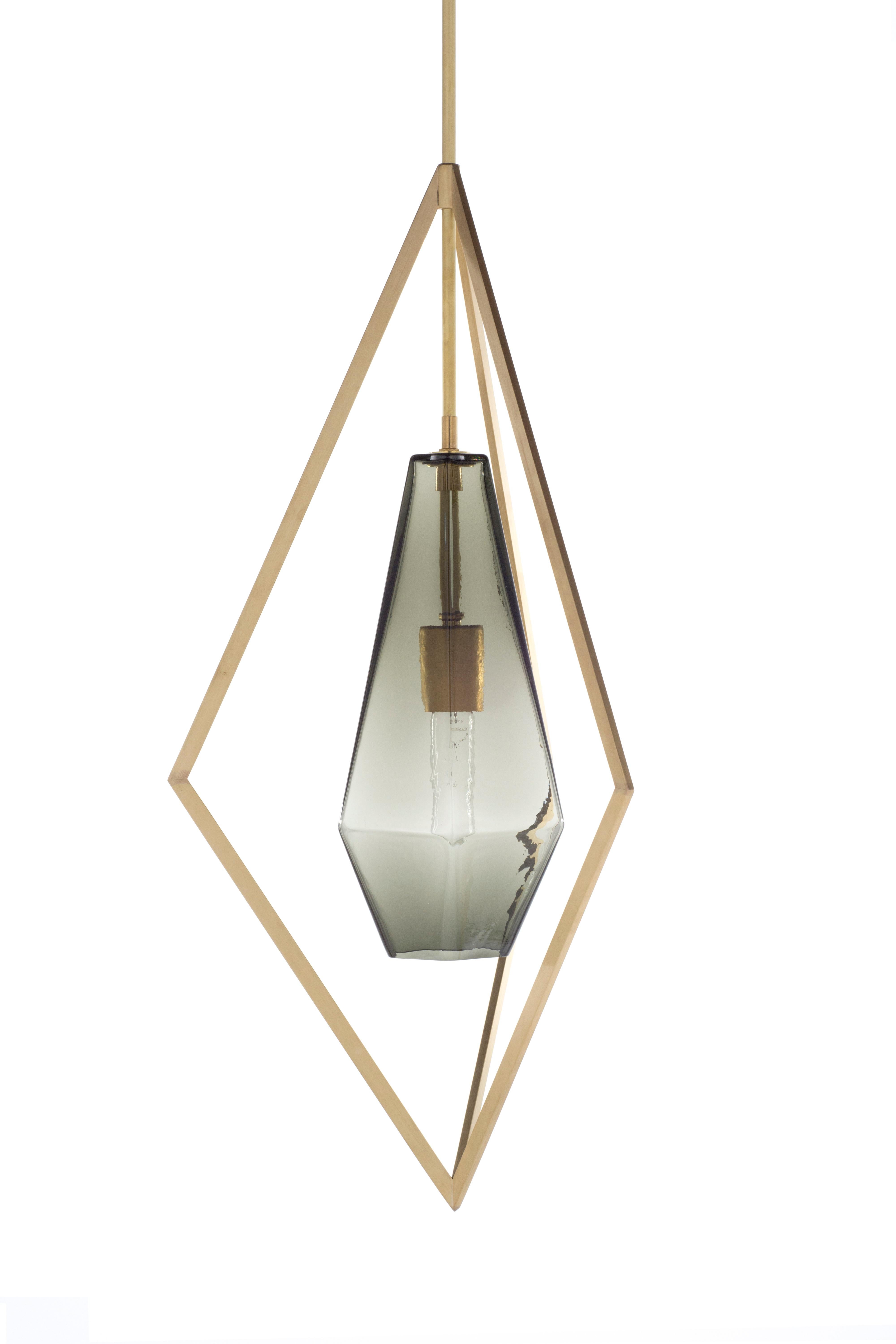 Exploring perceptions of gravity, a luminous arc eases a bar of marble, or gives way to and yet suspends a stone wheel. The large pendant is made of porcelain (option) neon, and brass and glass and plays with the illusion of weight and strength.

