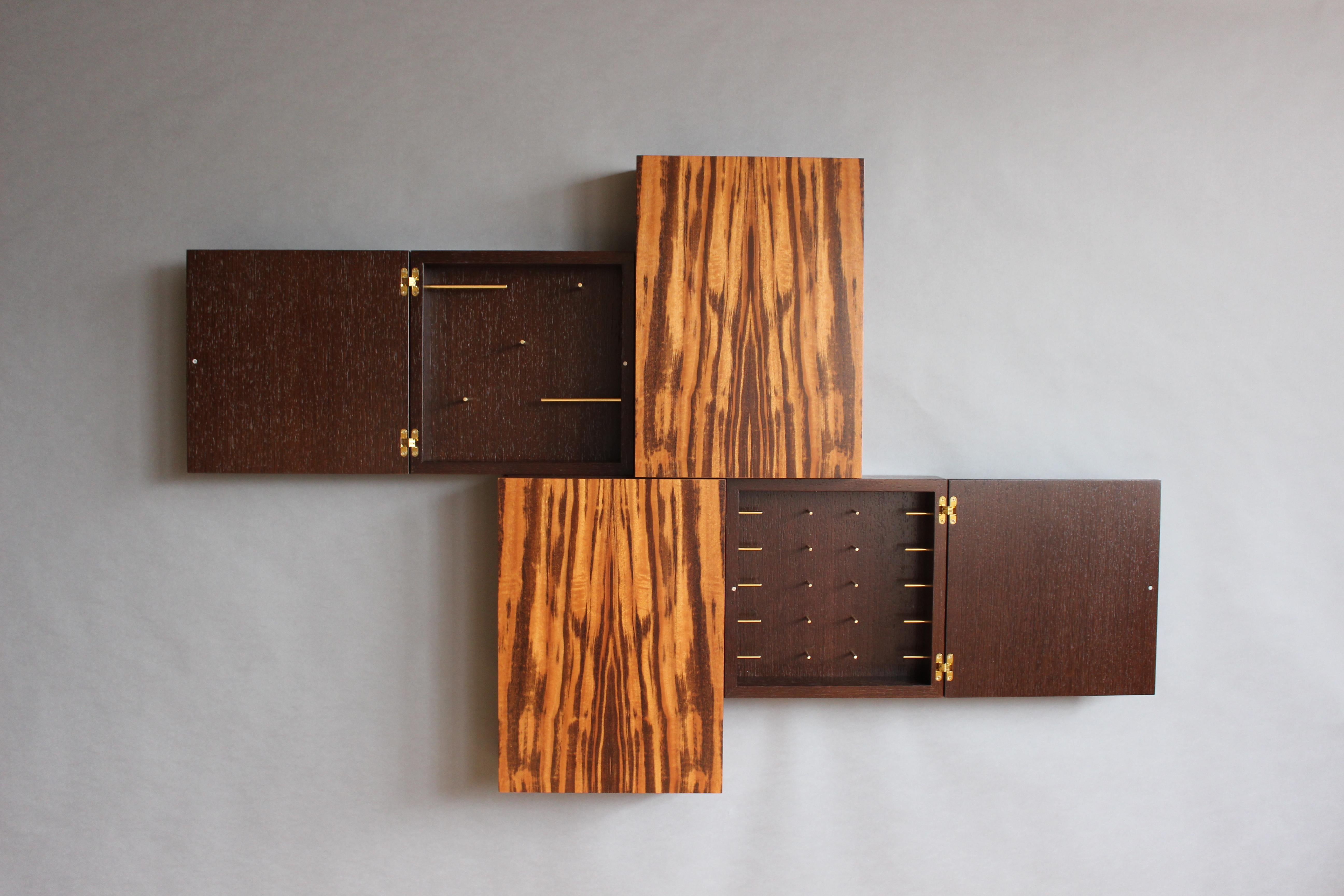 The Tetris Jewelry Case collection is an exploration into the connections between form & intrigue. At first glance they appear as a stunning wall piece, subtly inviting a closer study. Upon doing so one finds doors held shut by a tiny magnet, easily