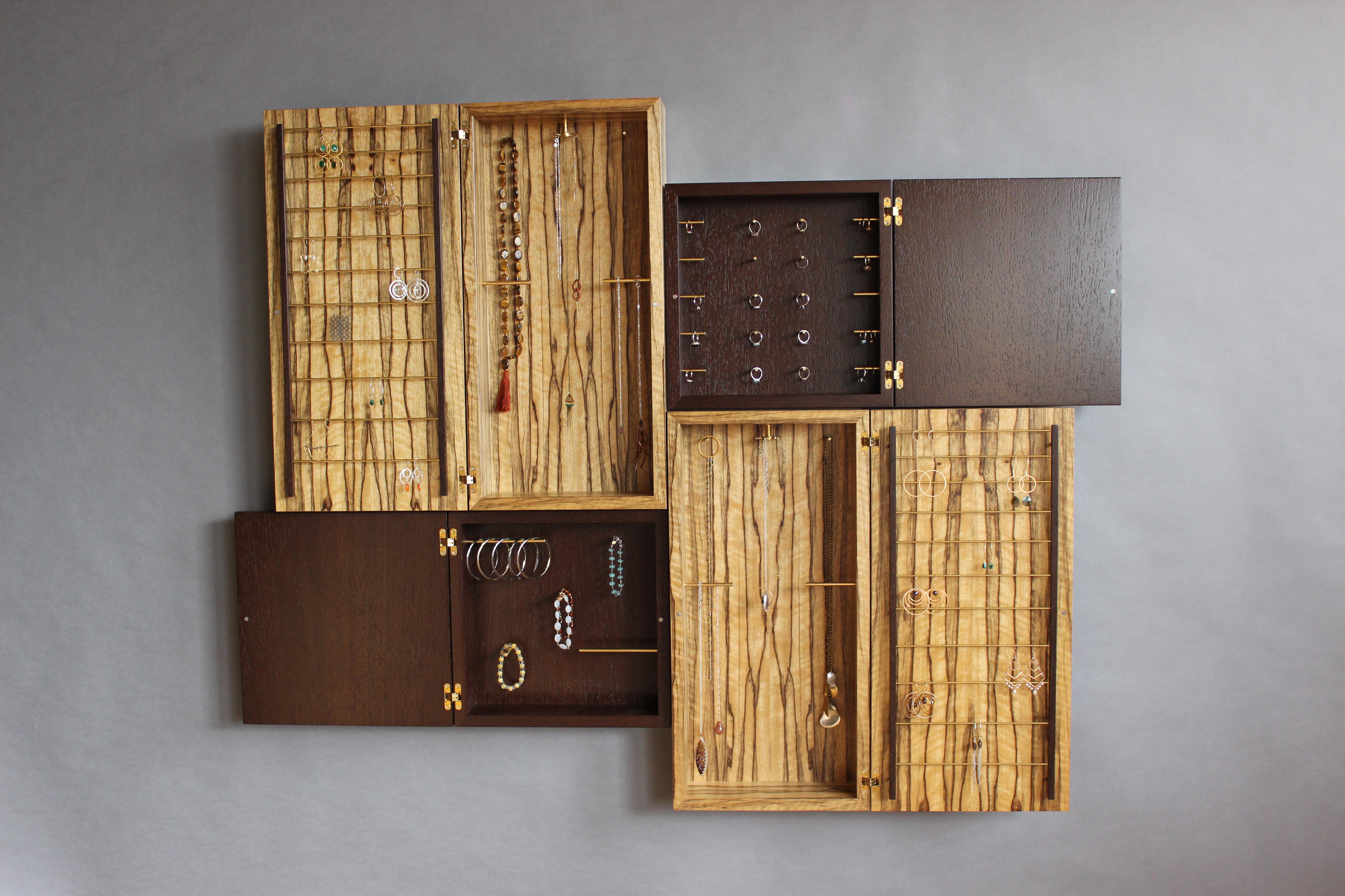 The Tetris Jewelry Case collection is an exploration into the connections between form & intrigue. At first glance they appear as a stunning wall piece, subtly inviting a closer study. Upon doing so one finds doors held shut by a tiny magnet, easily