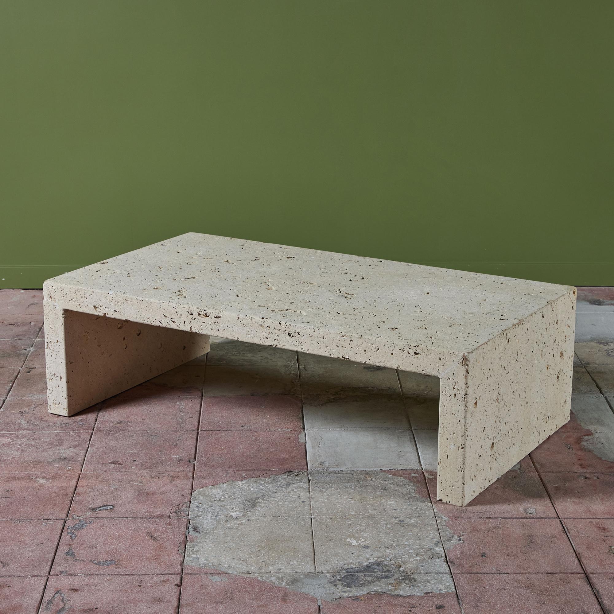Limestone rectangular coffee table also known as Texas Shellstone, has a thick table top with two waterfall edges, c.1970s, USA. This unique stone has many fossils and shells embedded through out the stone. With a sleek shape is reminiscent of