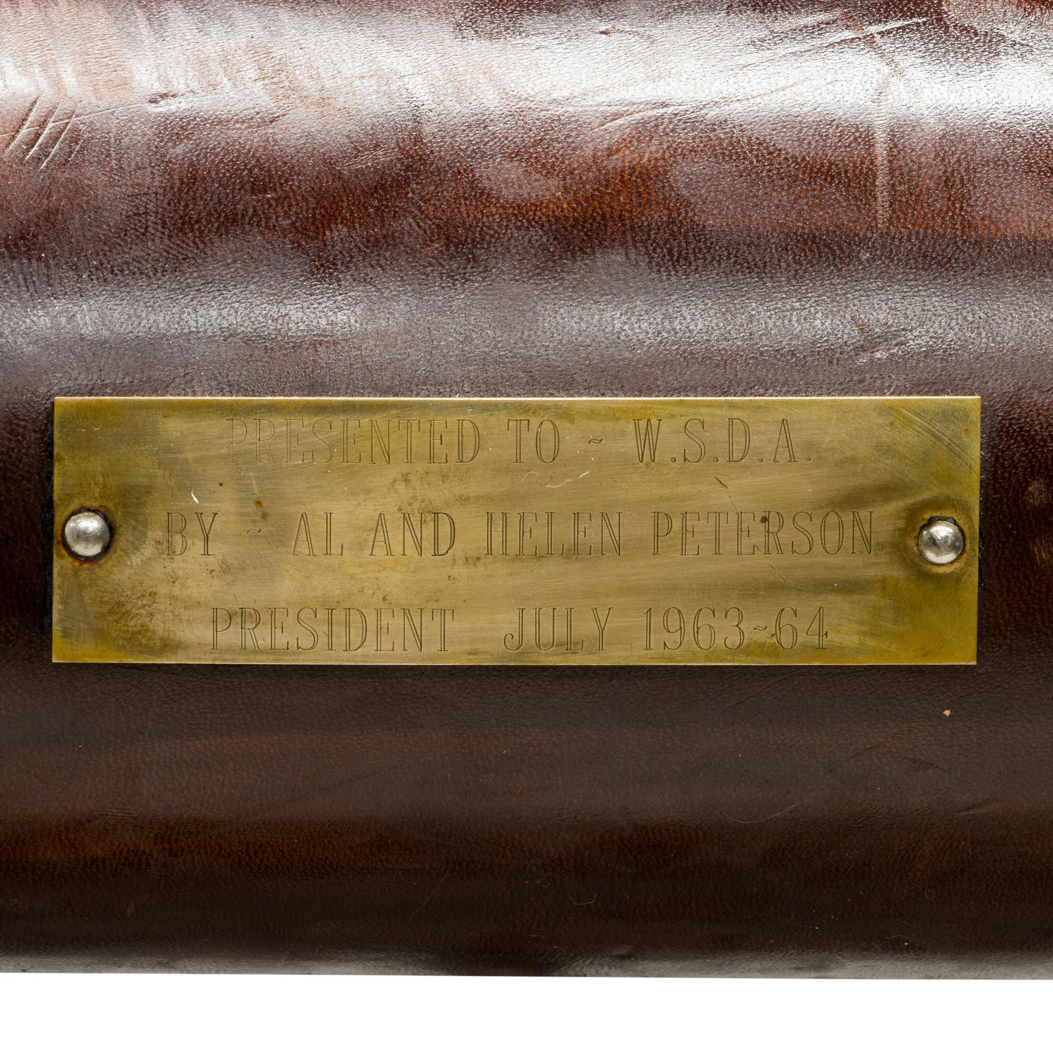 Texas longhorn trophy mount. Marked to brass plaque: Presented to W.S.D.A. by Al and Helen Petersen/President July 1963-64. Comprised of two cattle longhorns with riveted leather, mounted to wood backing and hoisted on extendable metal poles