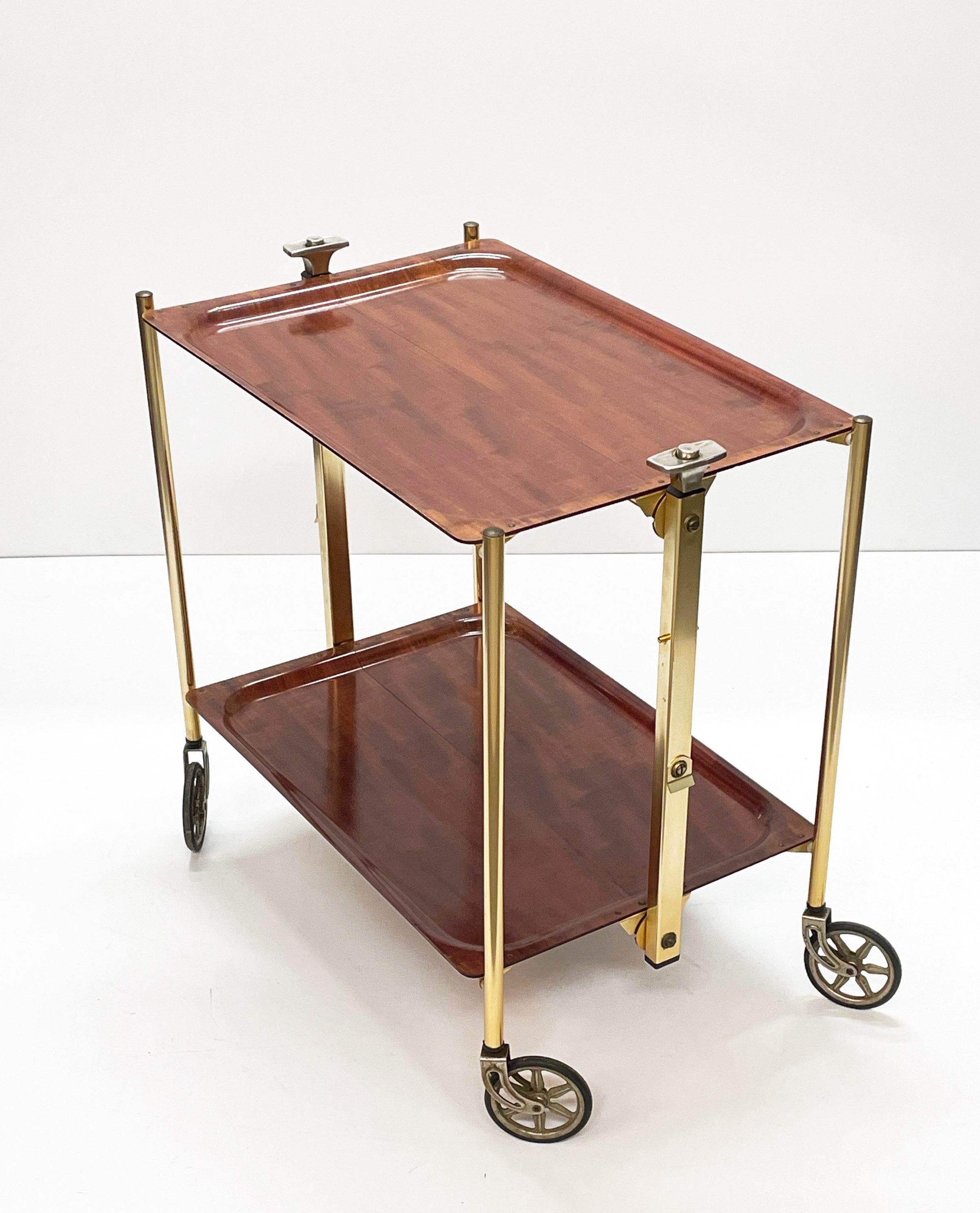 Food trolley in wood effect laminate and golden aluminium. This midcentury foldable beverage trolley was produced in the 1950s. 

This service trolley can also be used as a side table, and it is in wonderful vintage conditions. This piece is unique
