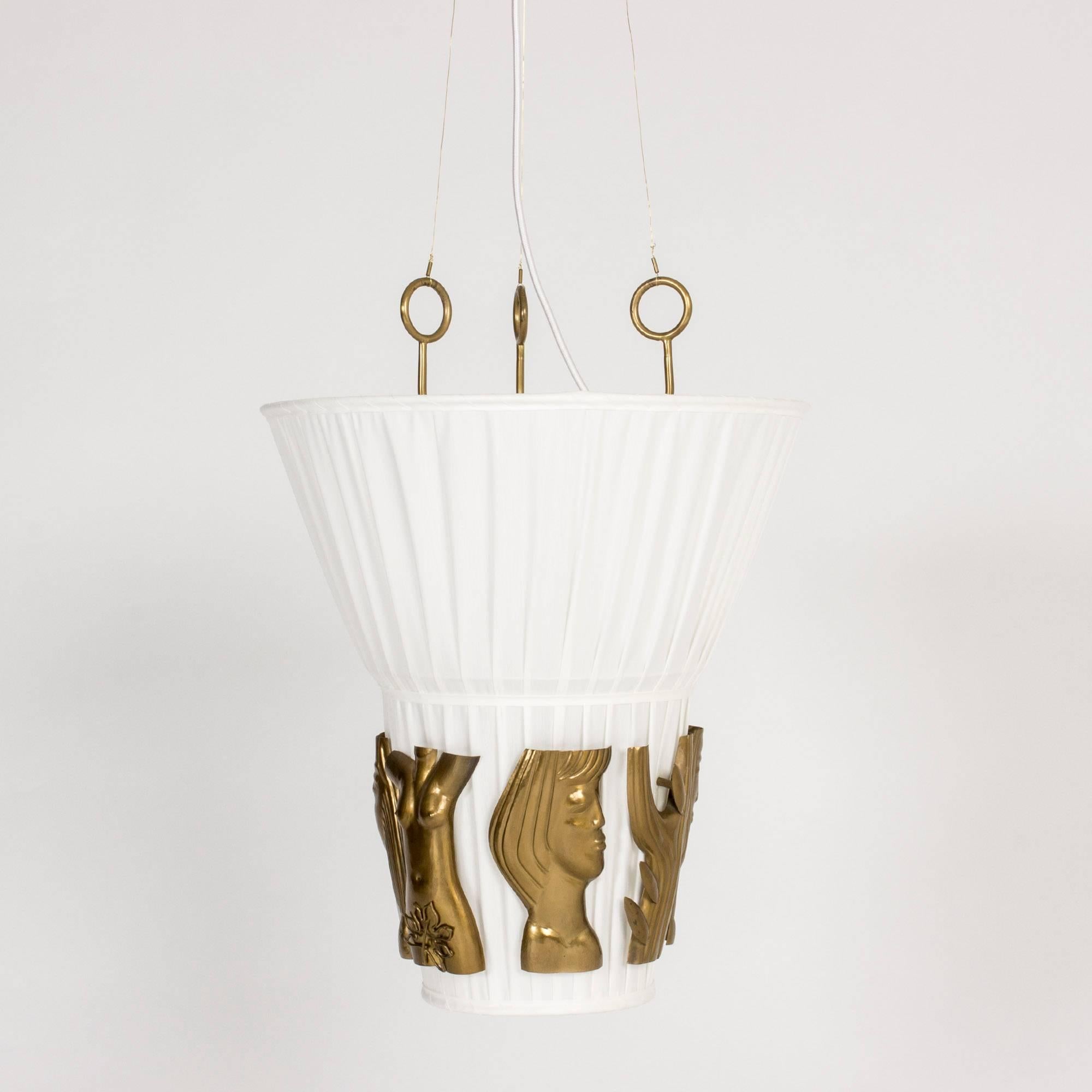 Stunning, rare ceiling light by Hans Bergström. Brass reliefs of women’s faces, bodies and branches on a white background makes this piece an artwork as much as a light. Slender brass threads suspend the light from its top, creating a floating