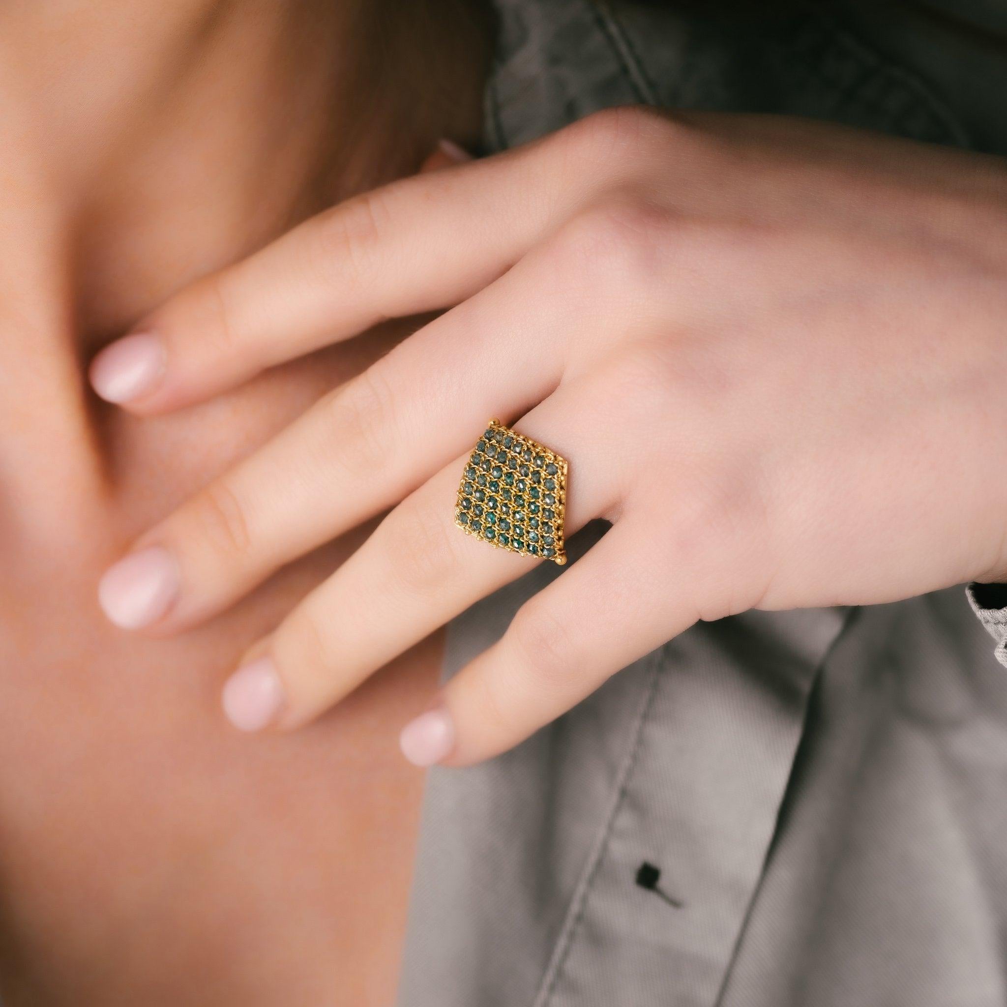 This eye-catching ring combines expert jewelry craftsmanship and traditional weaving techniques to create an unforgettable expanse of yellow gold chain hand woven with alluring Blue Diamonds. The result is an intricate textile-like swath of lustrous