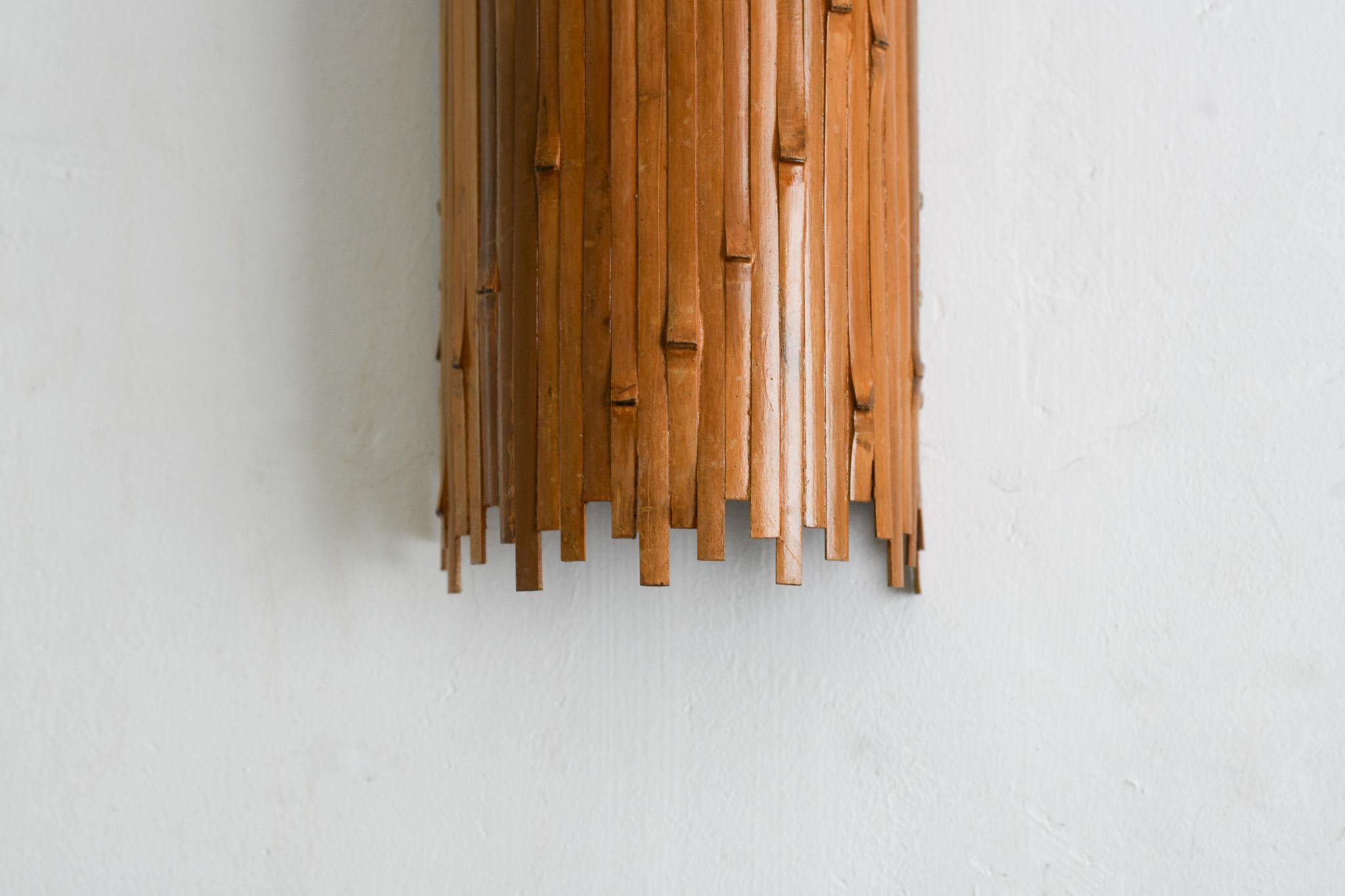 Eleva il tuo spazio con la nostra lampada da parete in bambù rovesciata, della serie Nodules di Rattanology. Realizzata a mano con vero bambù e rifinita con finiture dorate, questa lampada emana vibrazioni moderne di metà secolo. Un'aggiunta unica a