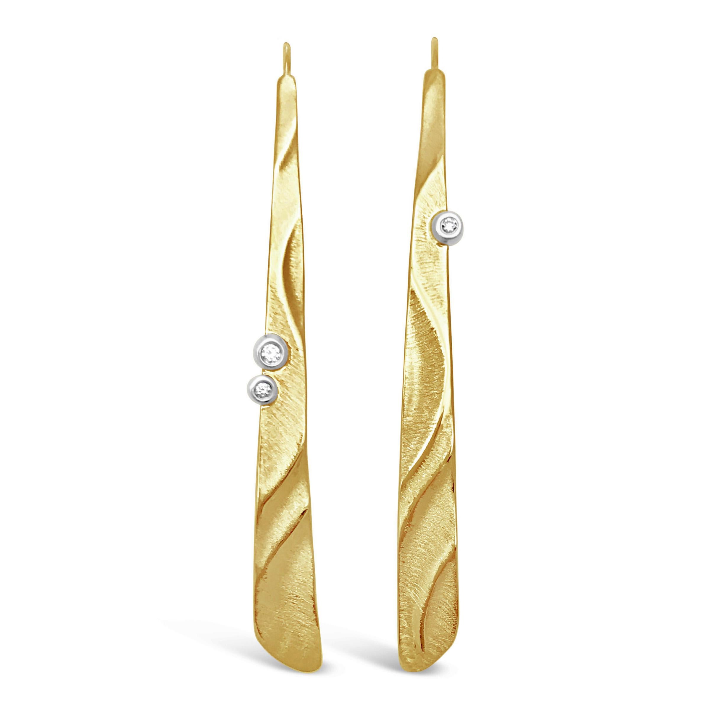 Keiko Mita's Long Puzzle Earrings, which are 59 mm l x 6 mm w, are handmade from 14 Karat Yellow Gold and 0.03 carats Diamonds set in 14 Karat white gold. The artist's puzzle pattern and signature Sand Dune texture continue from left to right. 
