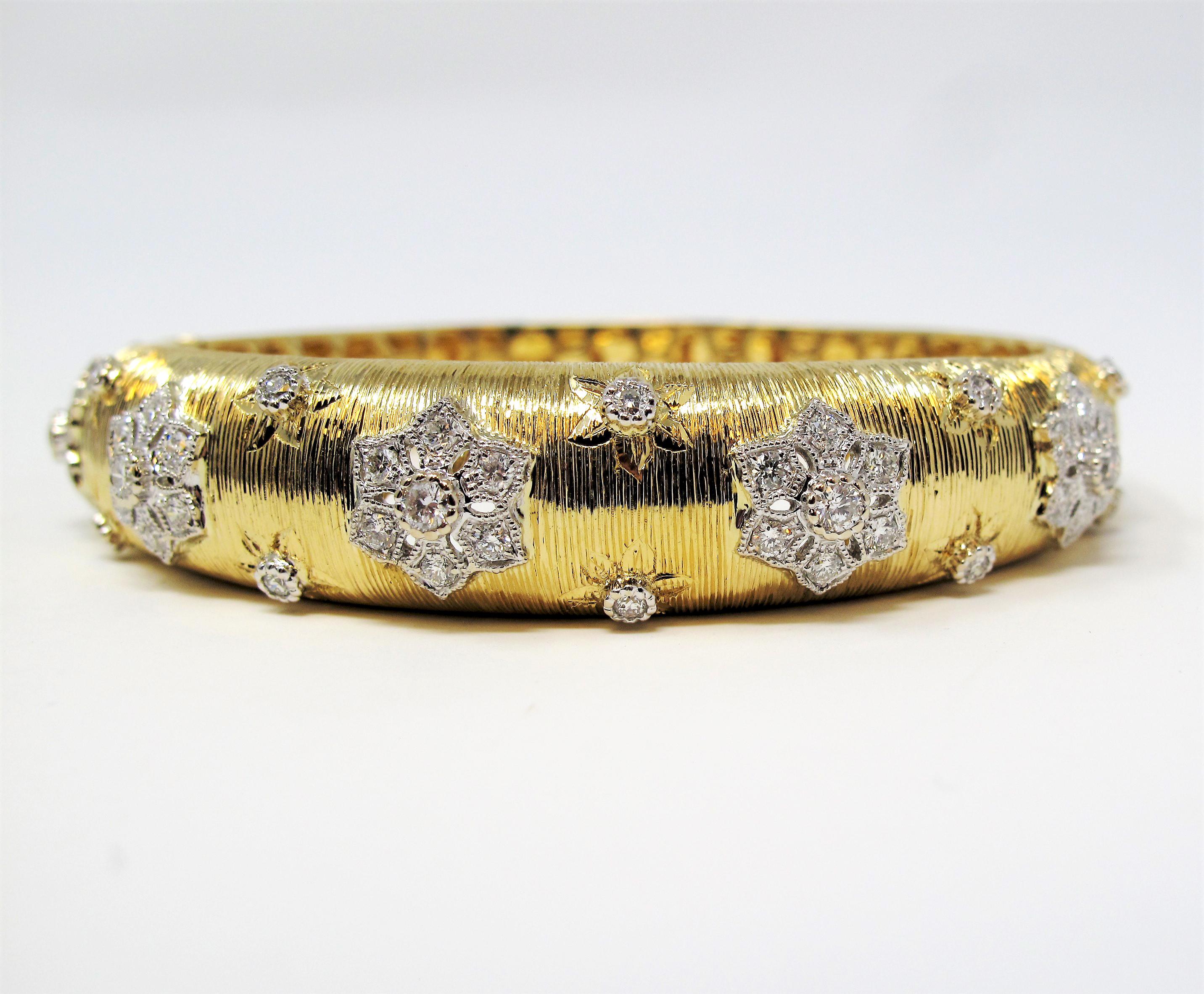 Fall in love with this romantic diamond floral bangle bracelet. This beautiful  piece features a textured yellow gold bracelet embellished with sparkling round white diamonds set in a floral design. It has a stunning elegance without being over the