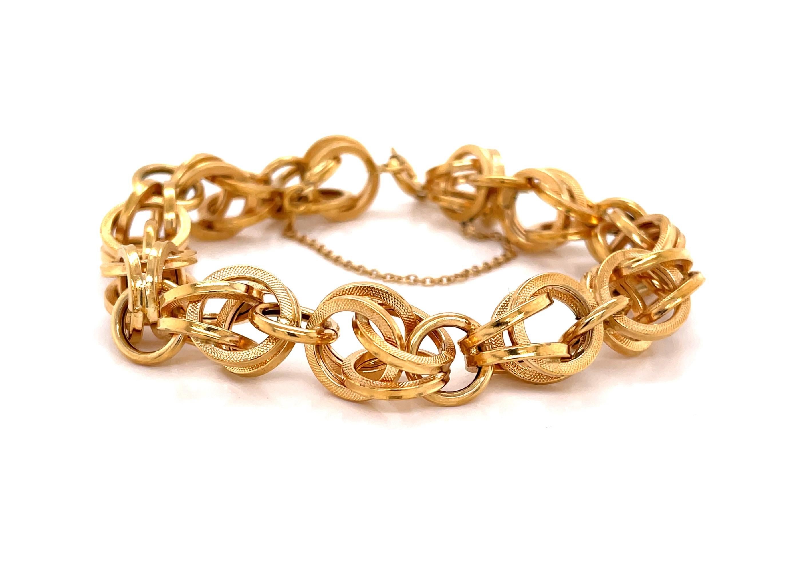 Integrated double links of bright and satin eighteen karat 18K yellow gold reflect plenty of light and create interest on this timeless eight inch chain link style bracelet. With a moderate overall width measurement of approximately 11.5mm, this