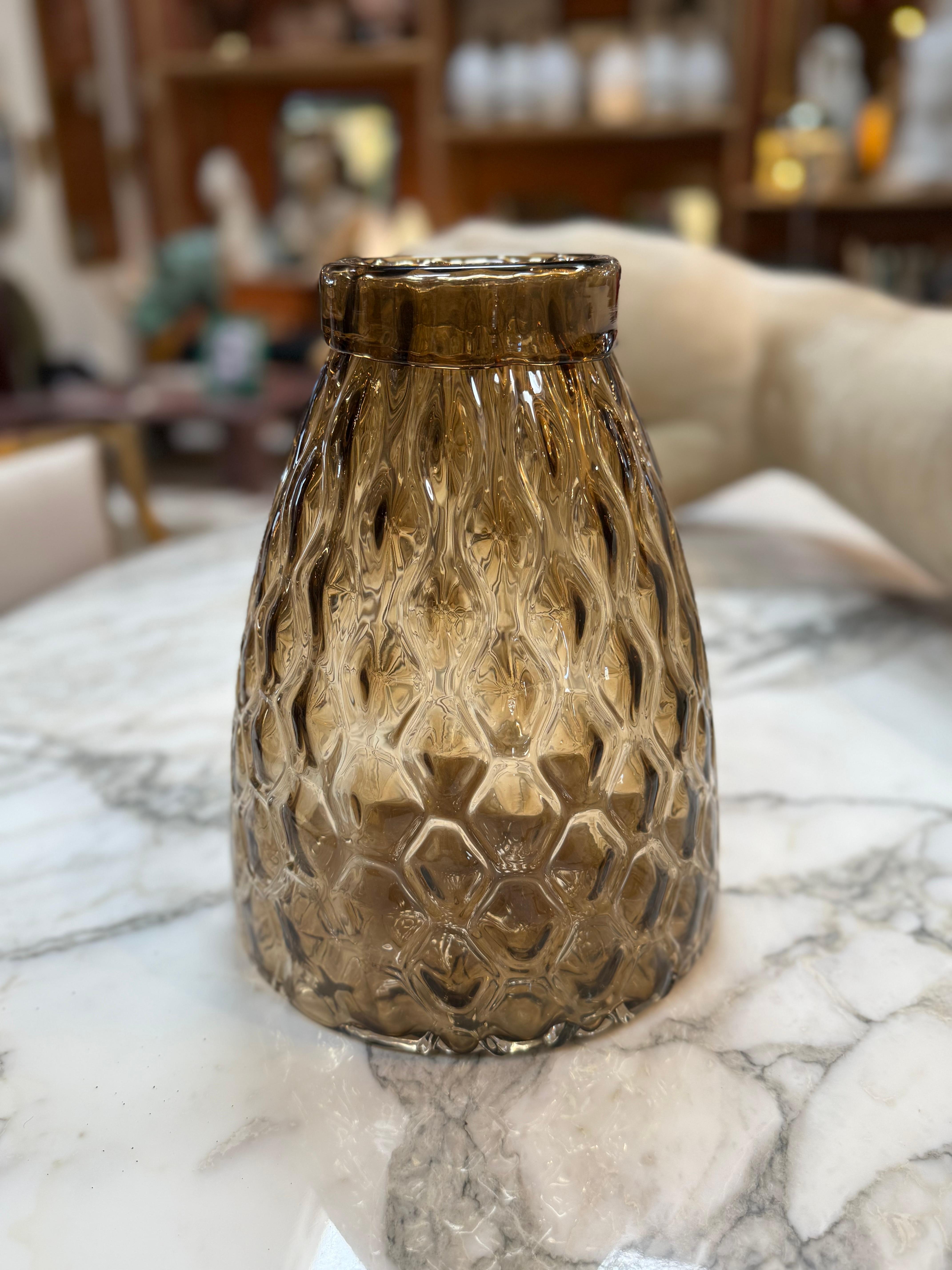 Charming amber glass vase featuring a diamond-patterned textured surface that catches and reflects light beautifully. The warm golden-brown hue and rounded silhouette give it a vintage yet modern appeal, perfect for adding warmth and style to any
