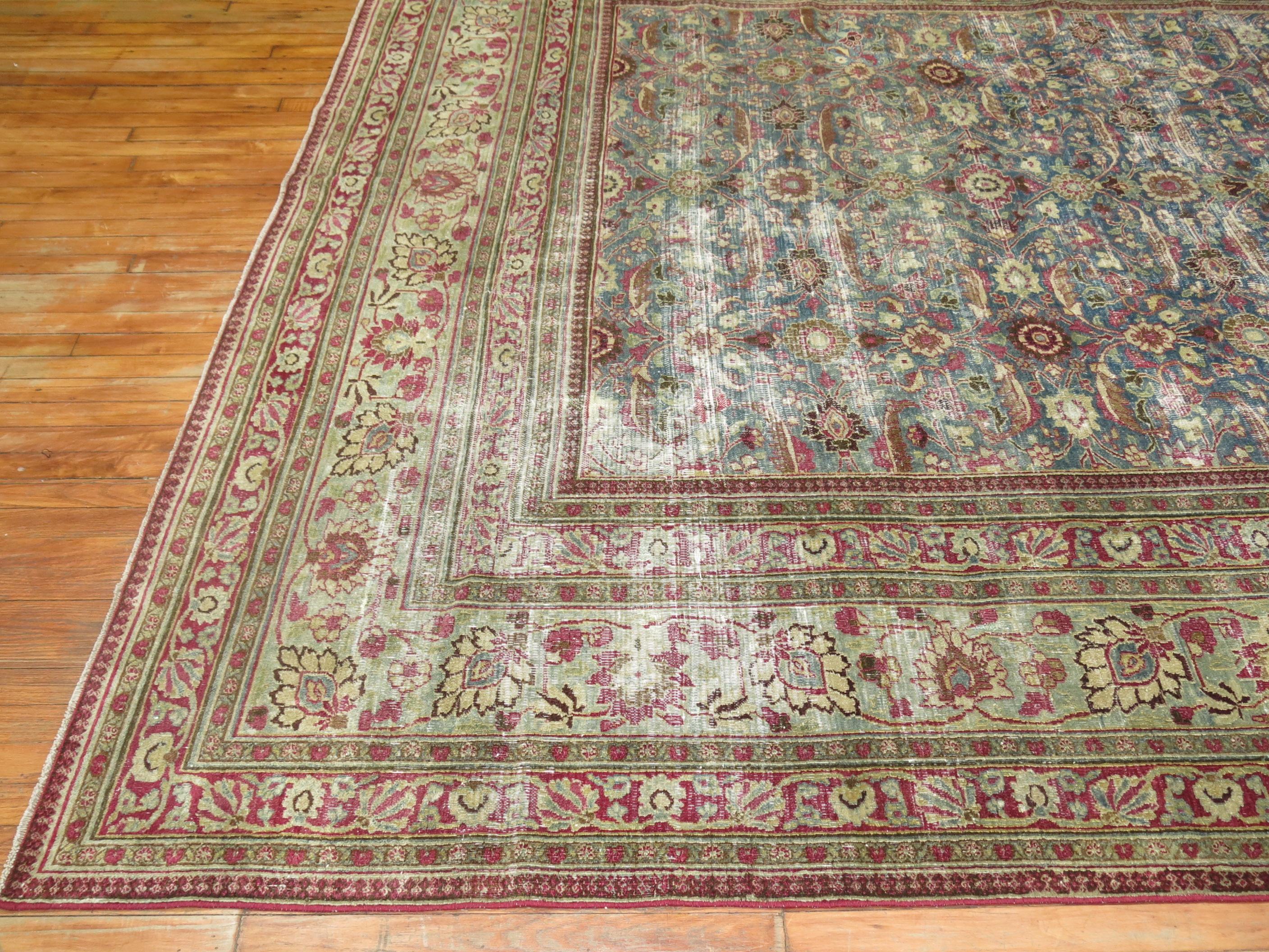 One of a kind shabby chic room size Persian rug from the meshed region. Predominantly blue and raspberry tones.