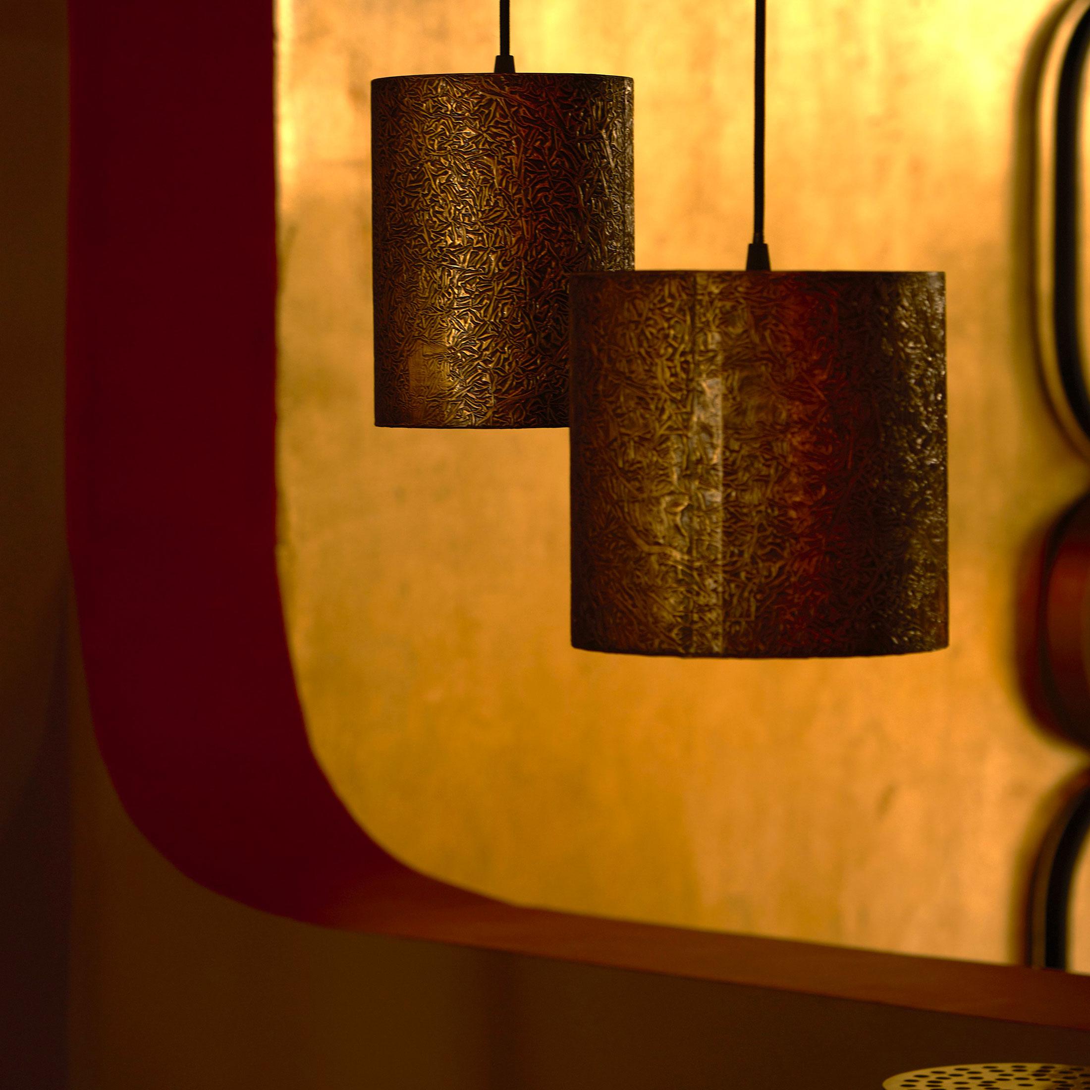 La lampe suspendue Victor en laiton texturé est composée de deux éléments cylindriques en laiton patiné, vendus ensemble. Chaque suspension est fabriquée à la main avec une finition texturée qui met en évidence les variations de surface et réagit à