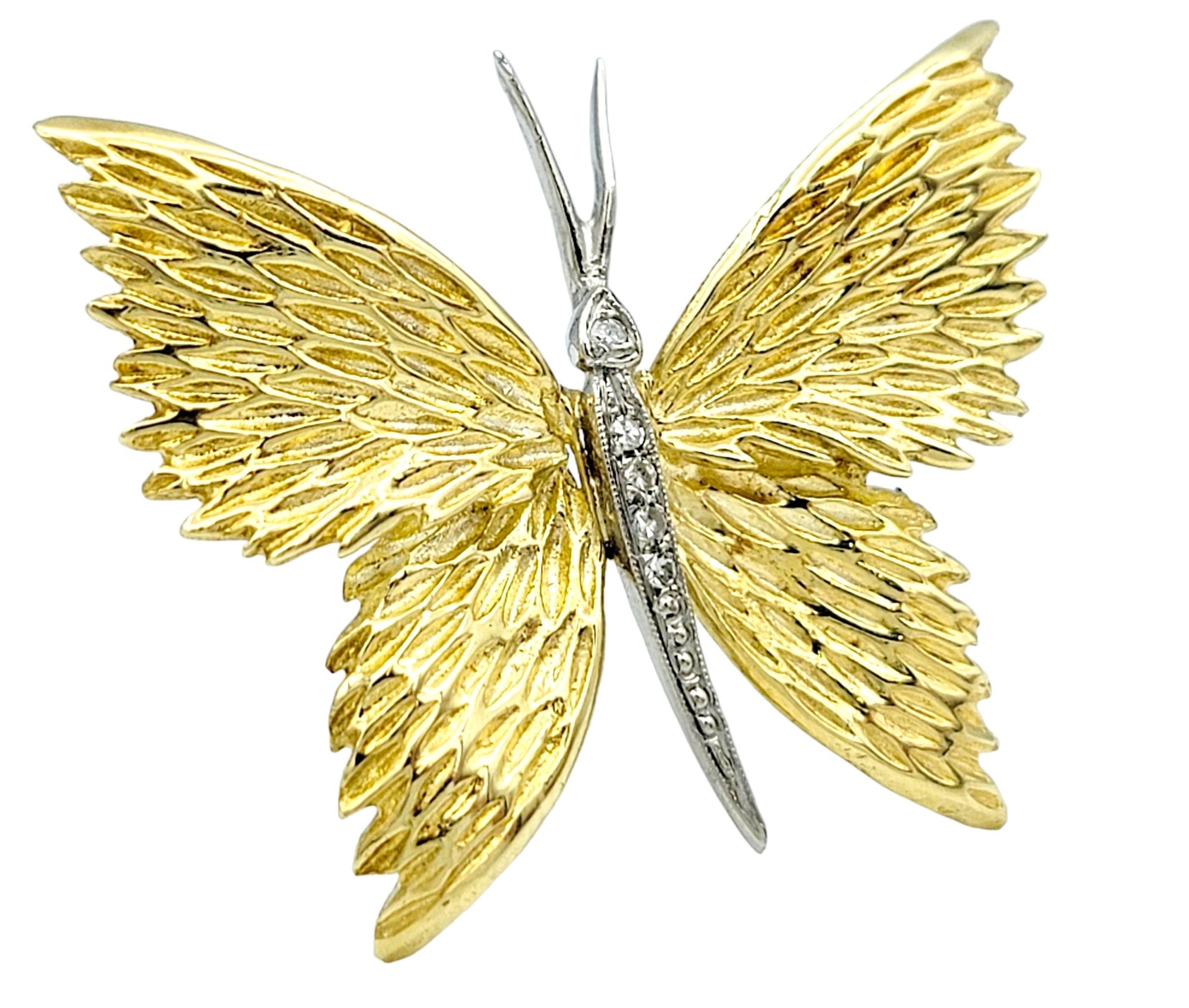 L'Elegance et la Nature convergent dans notre broche papillon exquise mais simple, sertie d'or 18 carats. La broche présente des ailes ornées de rainures texturées, créant un délicat jeu d'ombre et de lumière qui imite les motifs complexes des ailes