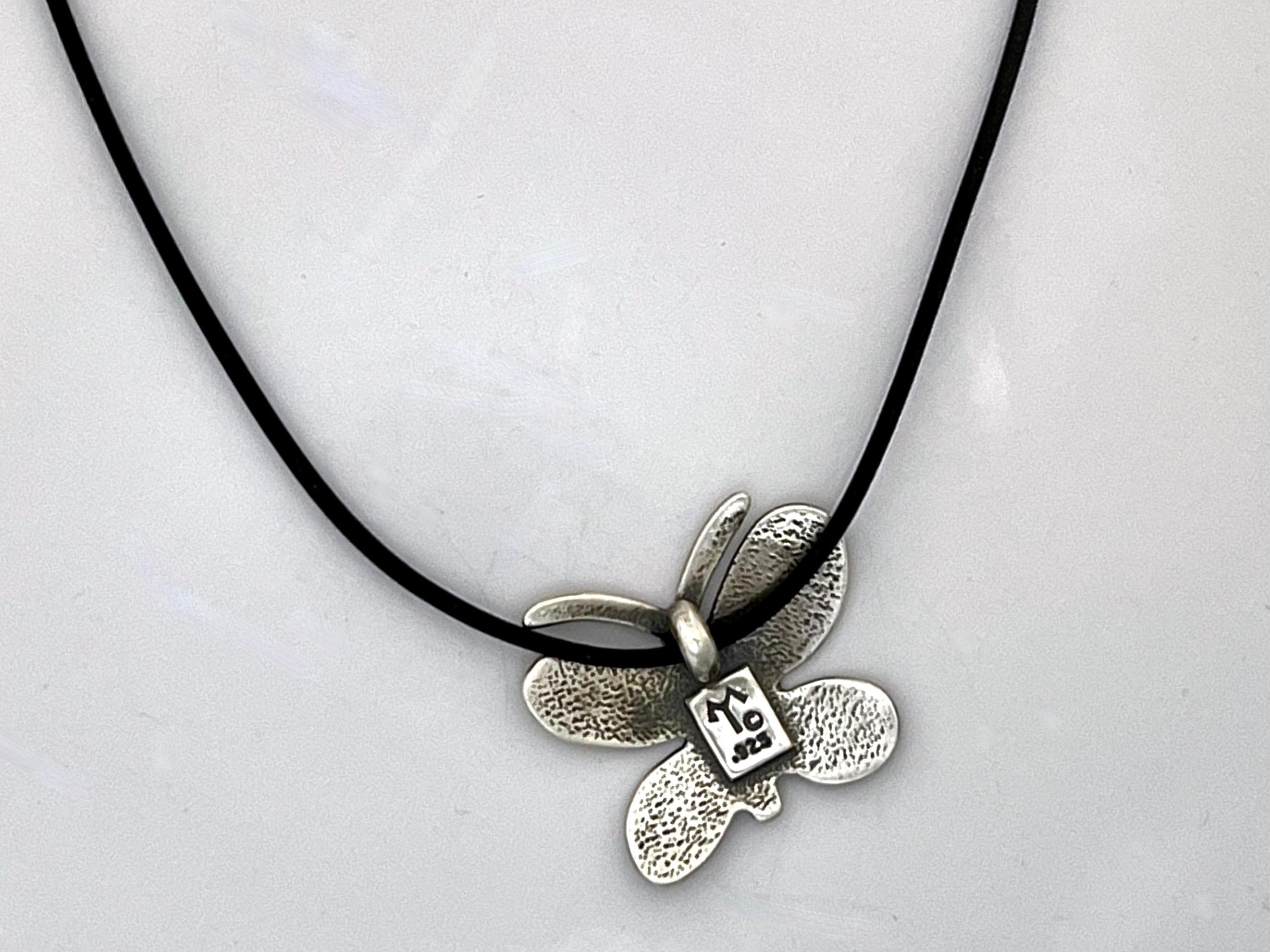 Textured Butterfly pendant, by Melanie Yazzie, Navajo, silver, black, necklace

Melanie A. Yazzie (Navajo-Diné) is a highly regarded multimedia artist known for her printmaking, paintings, sculpture, and jewelry designs. She has exhibited, lectured,