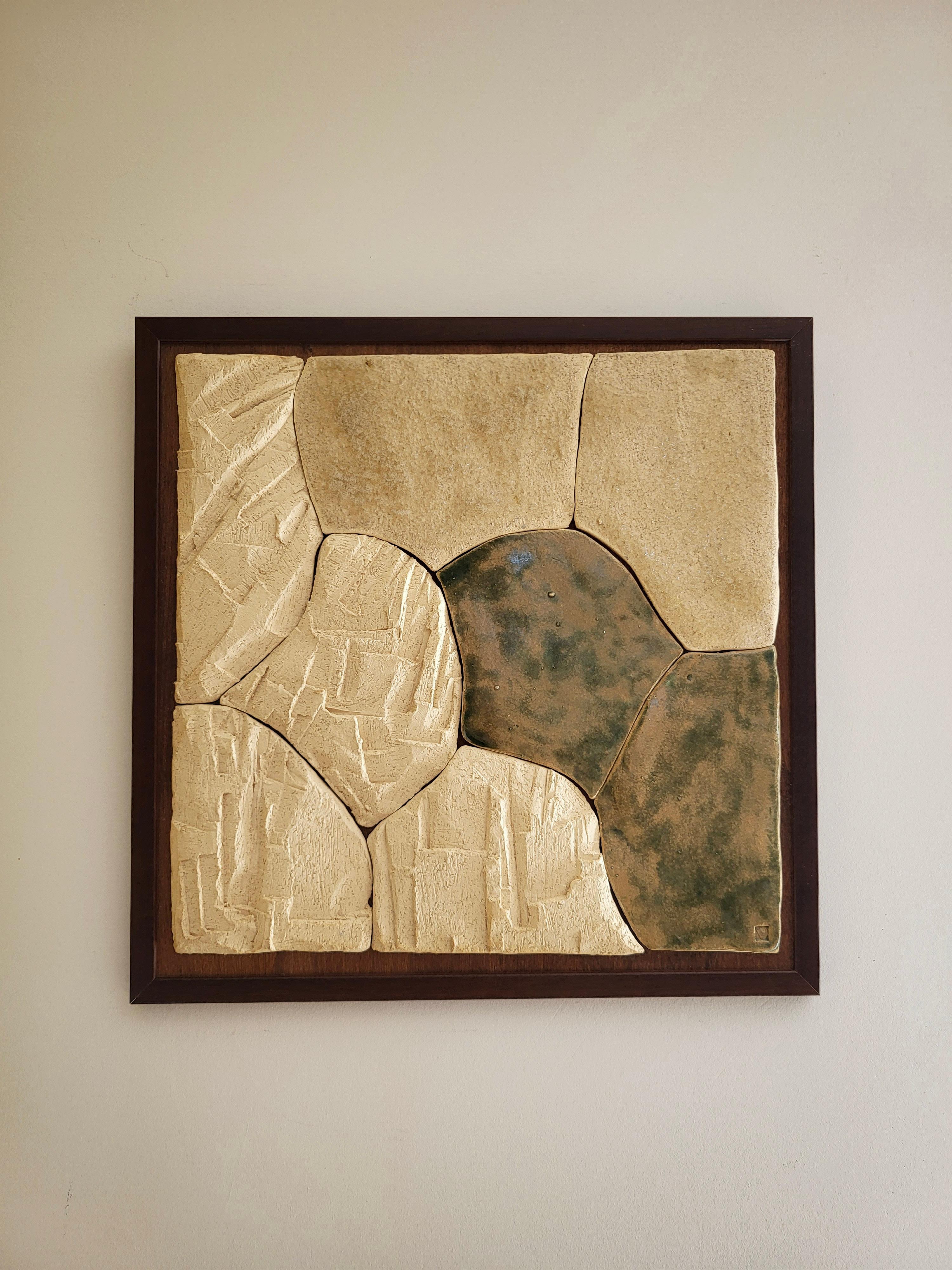 Fragmented Landscape V ist eine keramische Wandskulptur der französischen Künstlerin Audrey Vo Van, die aus handgefertigten Schamotte-Steinzeugfragmenten besteht, die auf einer dunklen Holzplatte angeordnet sind. Die Oberfläche zeigt einen Dialog