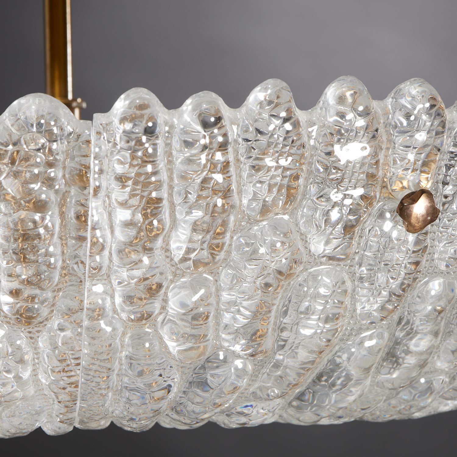 Textured clear glass and brass chandelier by Carl Fagerlund for Orrefors.
Mounted with 16 electrified sockets, includes canopy.