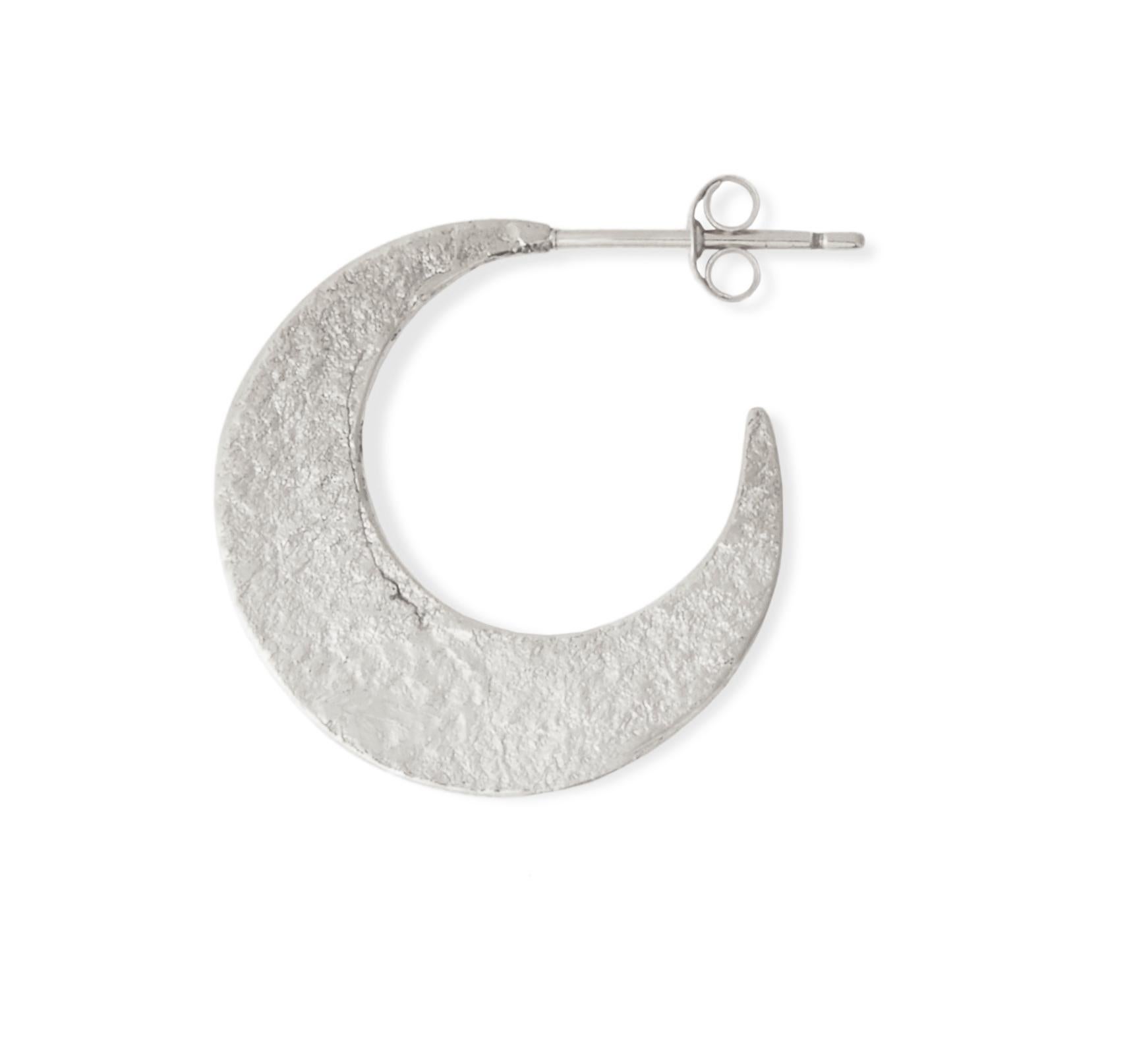 These textured crescent-shaped hoop earrings by Allison Bryan are handcrafted in  sterling silver with a post and butterfly closure.  They feature a shimmering texture on one side and a rustic high-polish finish on the other so can be worn with