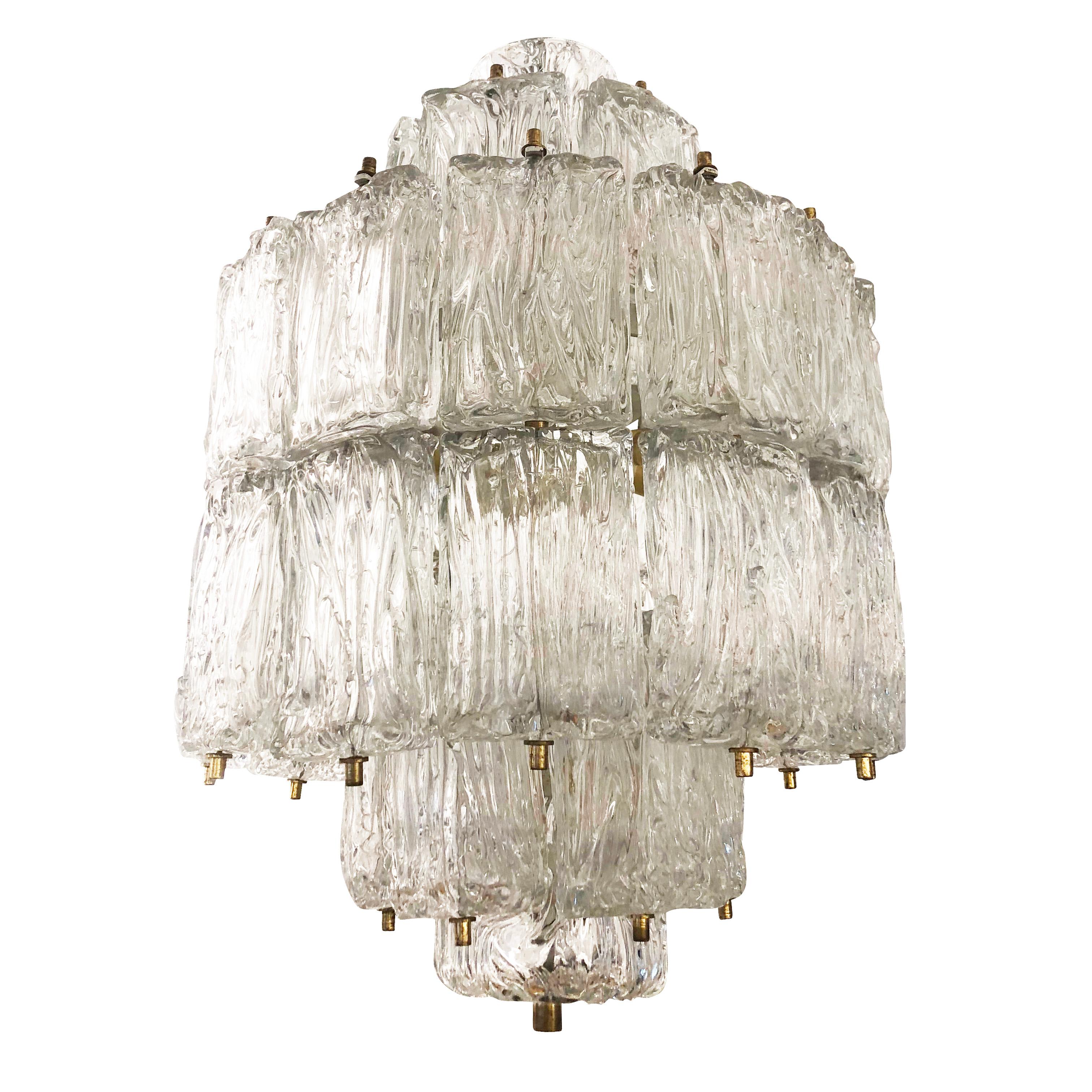 1950s Murano glass chandelier by Barovier and Toso composed of dozens of tiered textured glasses with brass fittings. Holds 12 candelabra sockets for an abundance of light. 

Condition: Excellent vintage condition, minor wear consistent with age and