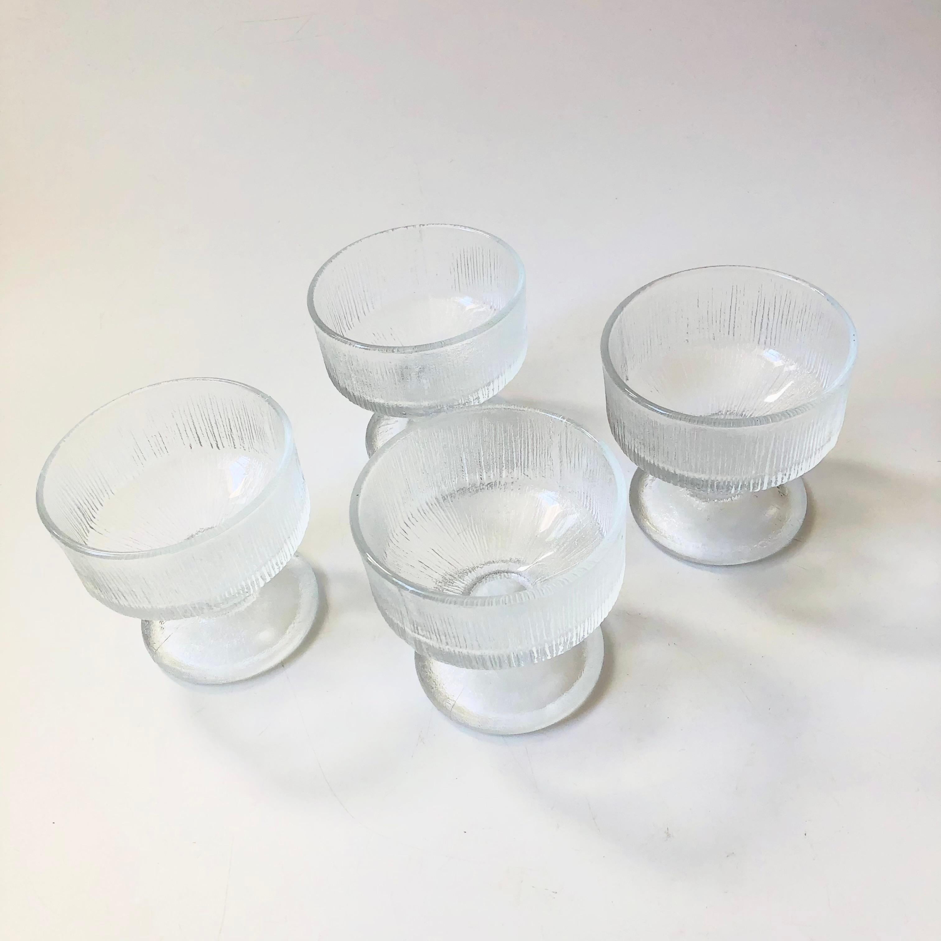 A set of 4 mid century glass coupes. Each has an elegant shape with a beautiful icey texture to the glass. Perfect for champagne or cocktails.

