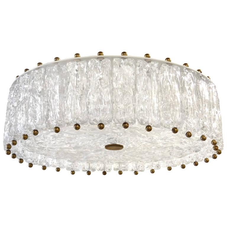 A textured glass fixture consisting of multiple piece of glass hung around a texture glass disk with brass hardware by Venini.

Italian, Circa 1960's