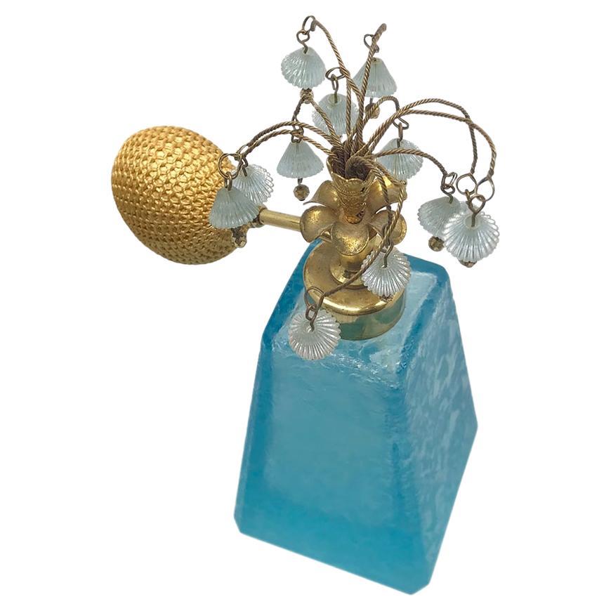 This is a blue botanic textured glass perfume bottle with floral atomizer top. It's working atomizer is decorated with dangling glass bell flowers. Made in West Germany after WWII, the original paper sticker is long gone. The bottle surface texture