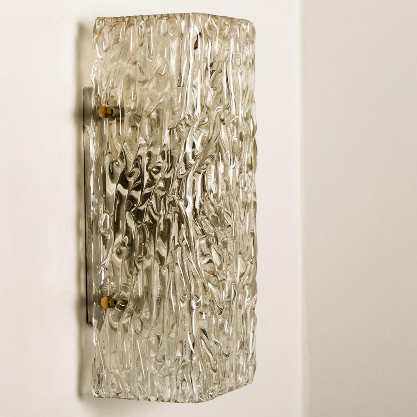 Uno dei quattro apparecchi di illuminazione di J.T. Kalmar, Vienna, Austria, prodotto nel 1960 circa. Il vetro presenta una bellissima texture a onde, che dona un effetto di luce diffusa e un bel disegno su soffitto, pareti e pavimento.
L'eleganza
