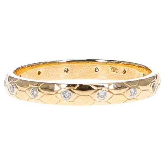 A Textured Gold Band with Diamonds, 18 karat yellow gold. The total weight of the diamonds is 0.08 carats. The total weight of the ring is 2.25 grams.
