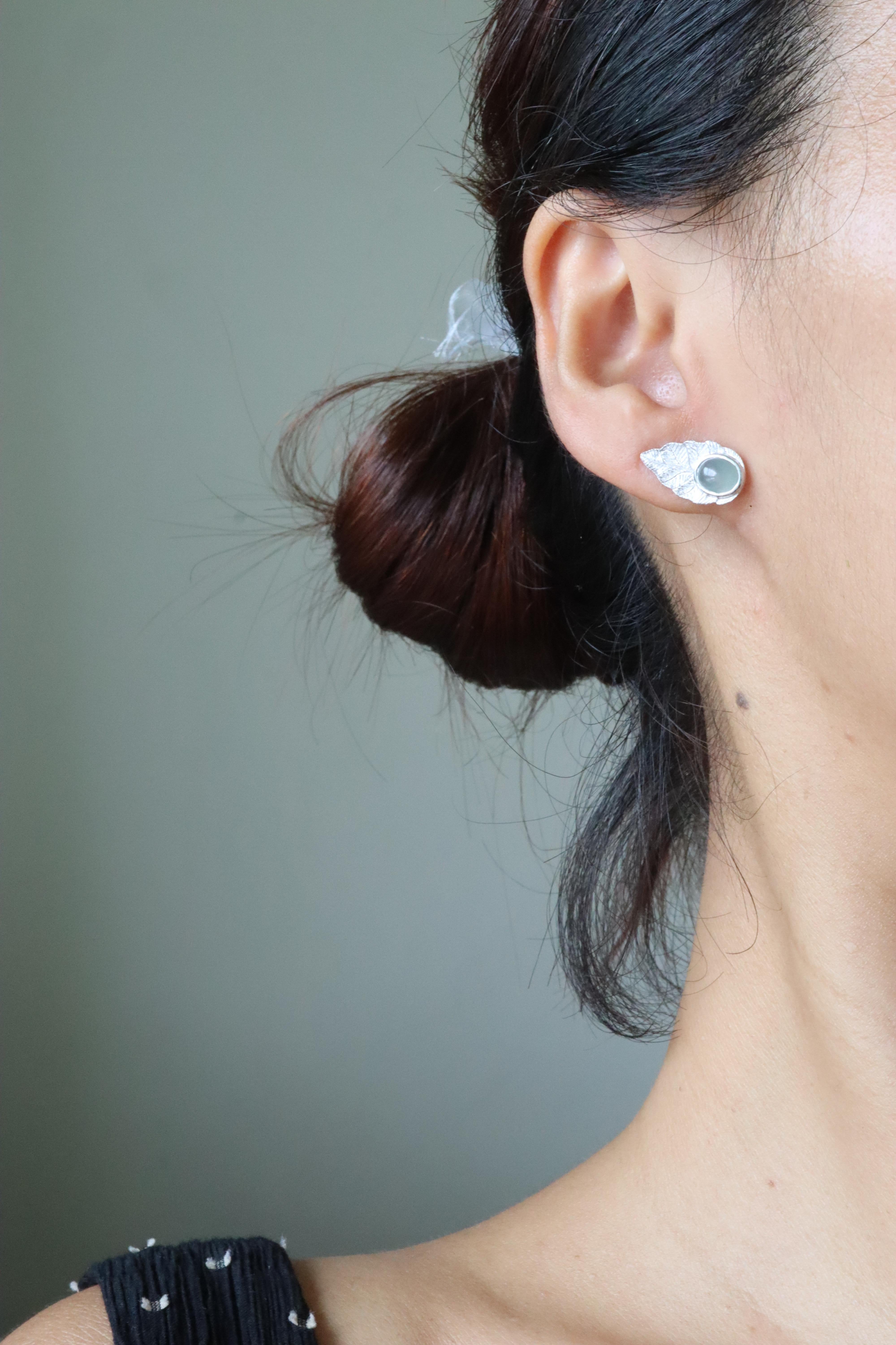 These earrings are crafted in 18k solid gold and feature a beautifully textured, brushed finish that mimics the look of natural leaves. They are accented with natural Type A jade, adding value and uniqueness to the design. Each earring showcases a
