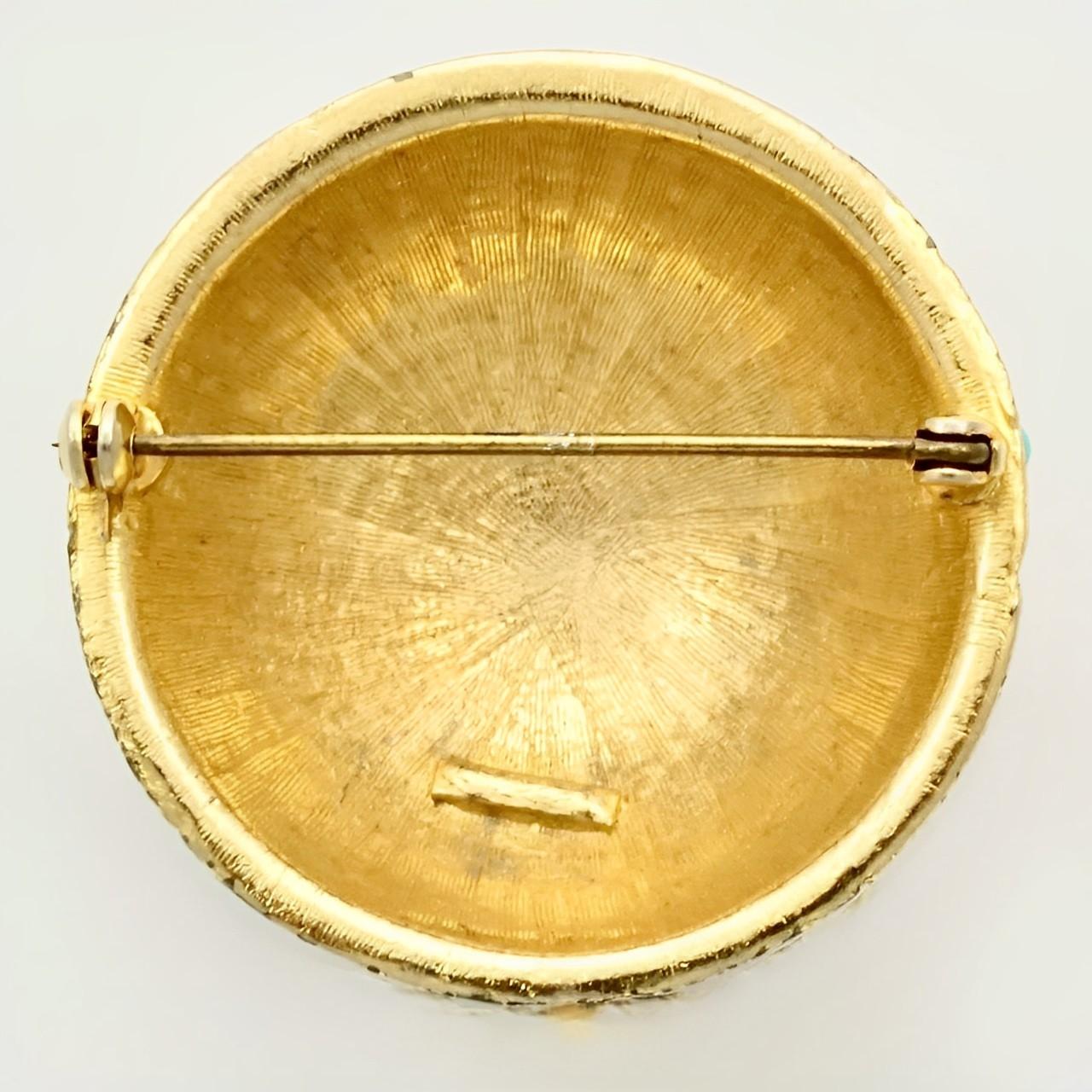 Wunderschöne, strukturierte, vergoldete Kuppelbrosche, besetzt mit türkisfarbenen Glassteinen. Messdurchmesser 4,15 cm / 1,6 Zoll. Die Vergoldung weist Gebrauchsspuren auf.

Dies ist eine ungewöhnliche Brosche aus den 1970er Jahren.