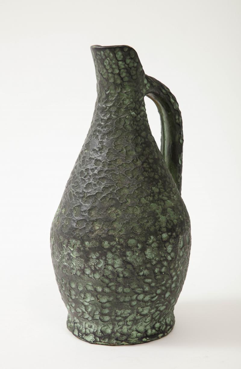 Texturierte, grün glasierte Terrakotta-Vase/Krug, Spanien, 20.

Wunderschön strukturierter Keramikkrug in einer ausdrucksstarken dunkelgrau/grünen Glasur, die den handgefertigten Charakter des Stücks unterstreicht. Sie sind gleichzeitig antik und