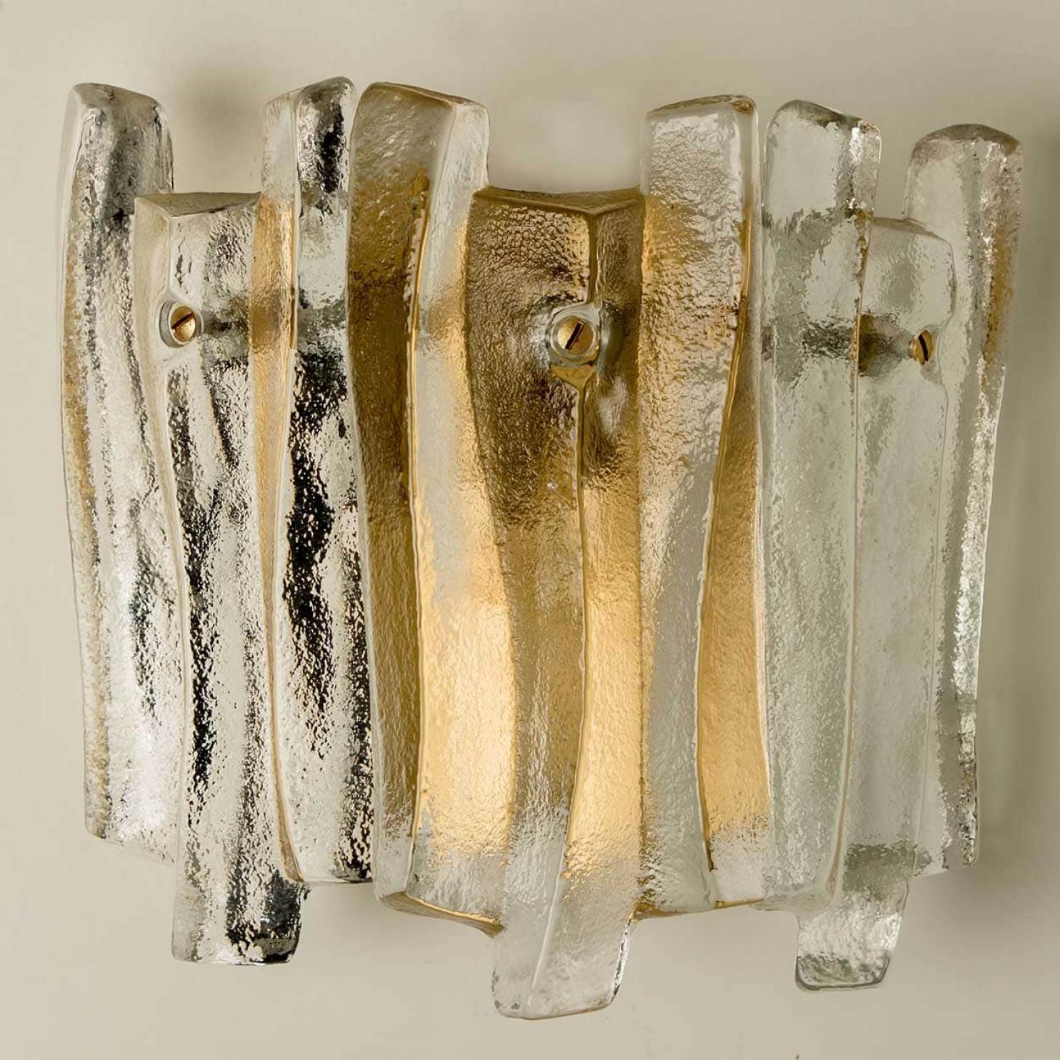 De belles et élégantes appliques modernes dans le style de Kalmar dans les années 1970. Un beau design. Neuf poutres en verre épais et texturé, de forme organique et ondulée. Le verre transparent a un aspect glacé et artisanal, créant un effet