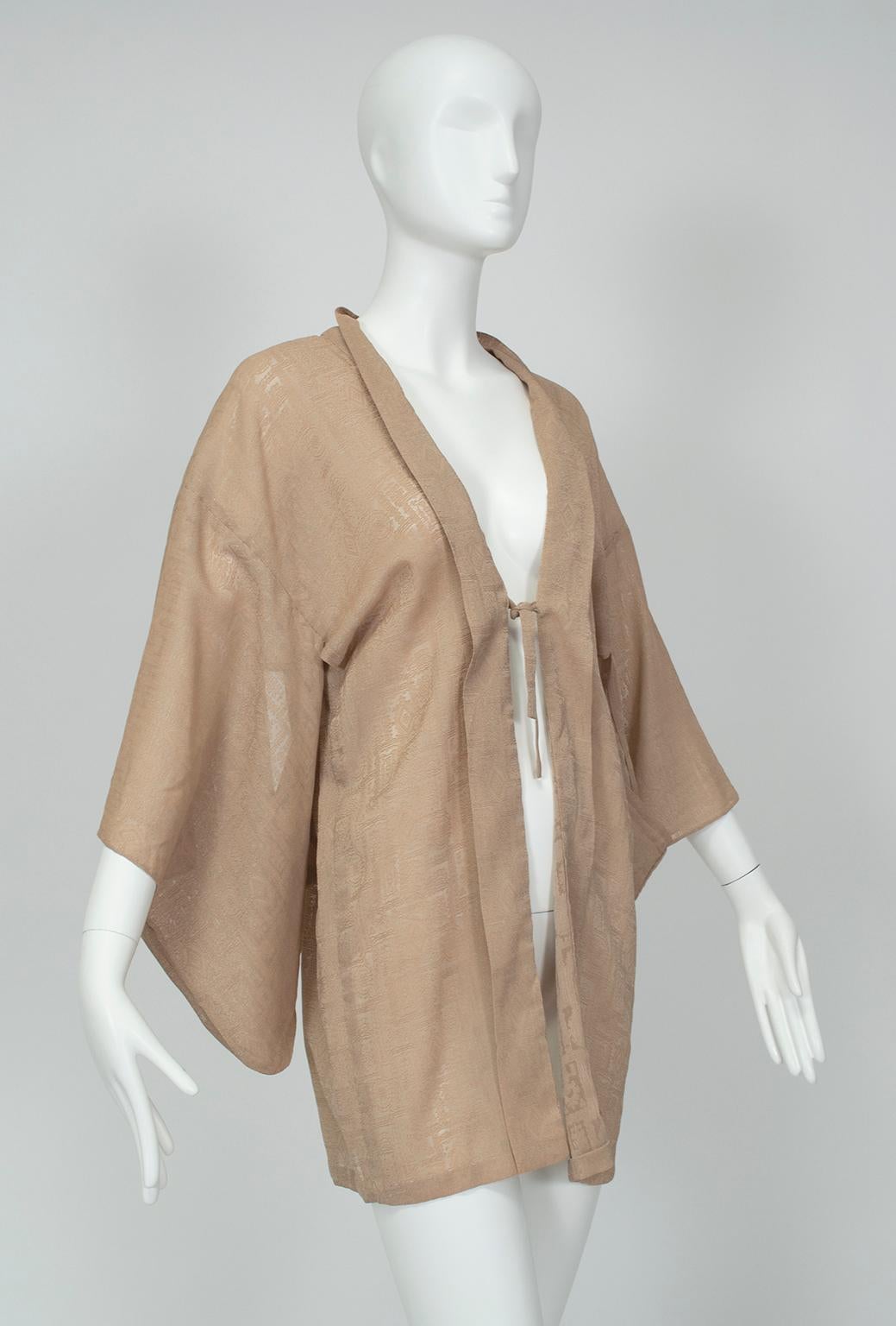 Sometimes called iro muji, short kimonos can act as lingerie cover-ups as well as lightweight blouses or jackets. In a versatile putty color, this unusual version features rich texture and a single tie closure that creates an alluring plunging