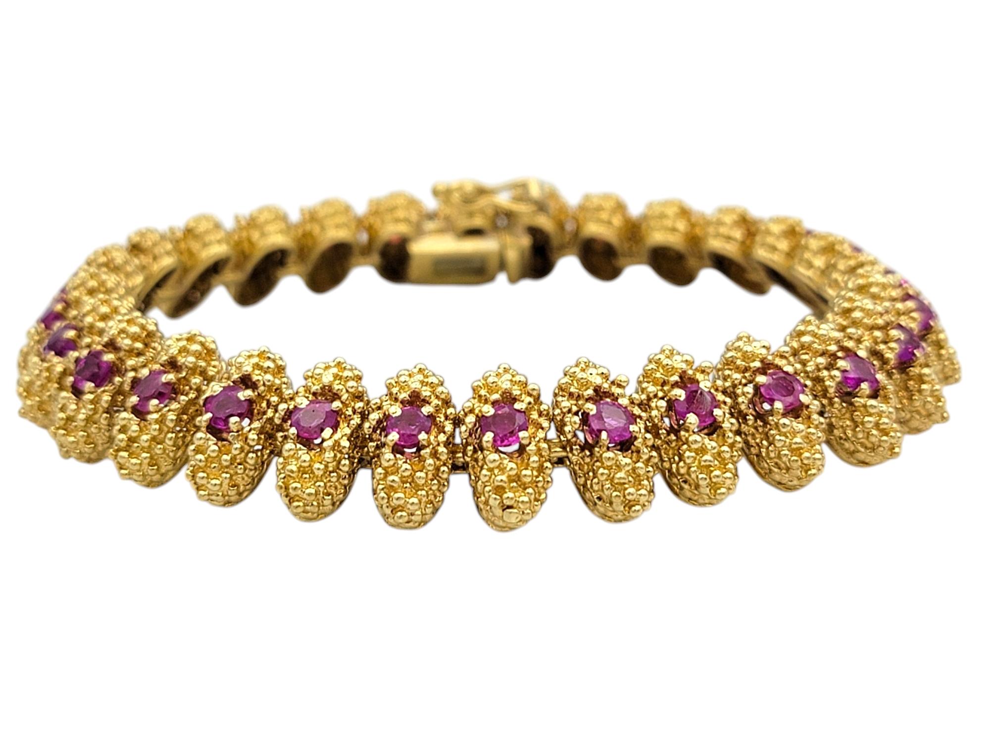 Elevate your collection with this exquisite 18 karat yellow gold ruby bracelet, a masterpiece of texture and brilliance. Featuring a series of intricately designed metal links, each adorned with vivid round-cut natural rubies, this bracelet exudes