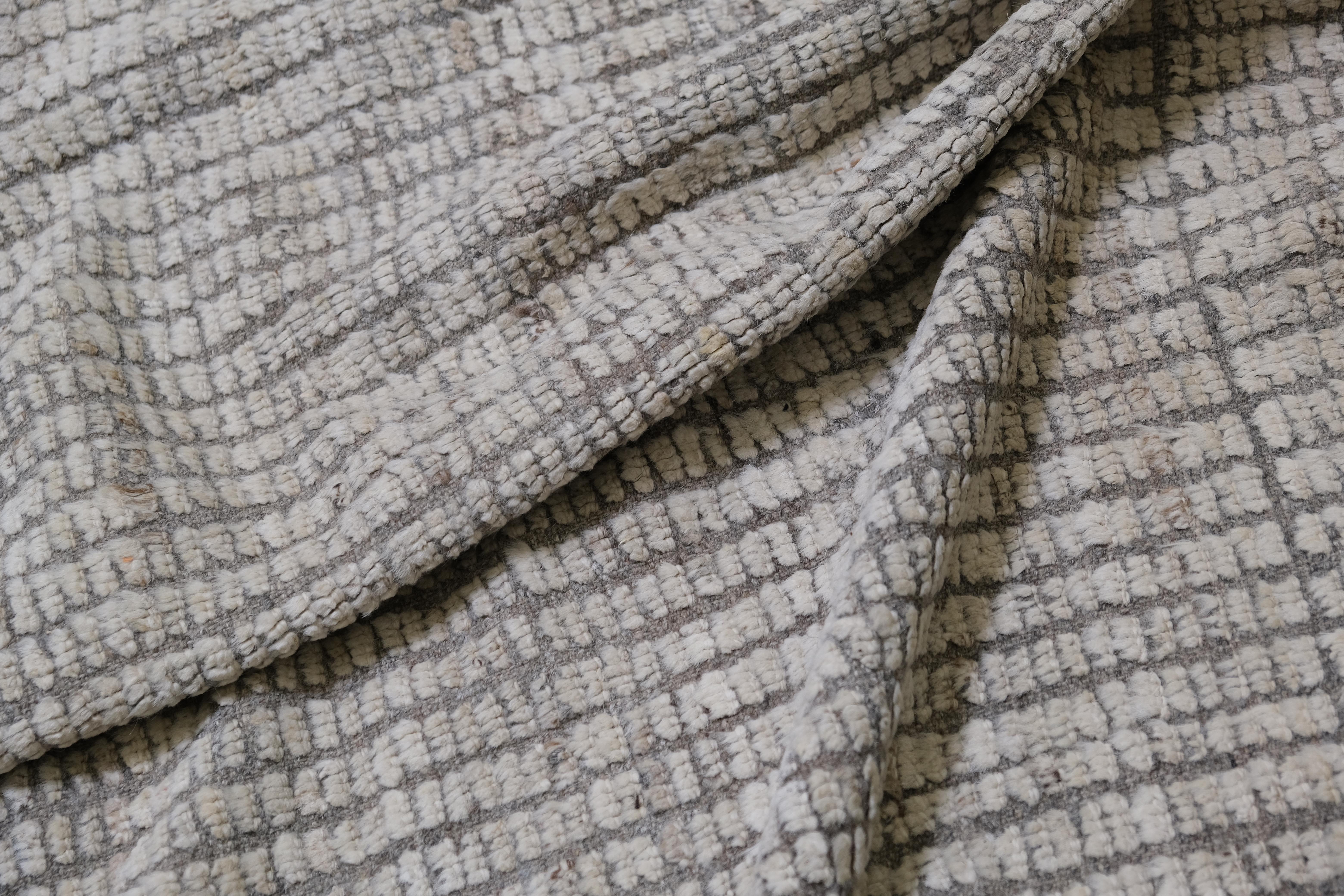 Dieser exquisite, handgeknüpfte Wollteppich aus Afghanistan ist ein Zeugnis der Kunstfertigkeit und des handwerklichen Könnens geschickter Knüpfer. Mit seinem modernen, linearen Design in einer beruhigenden Palette neutraler Töne verbindet dieser