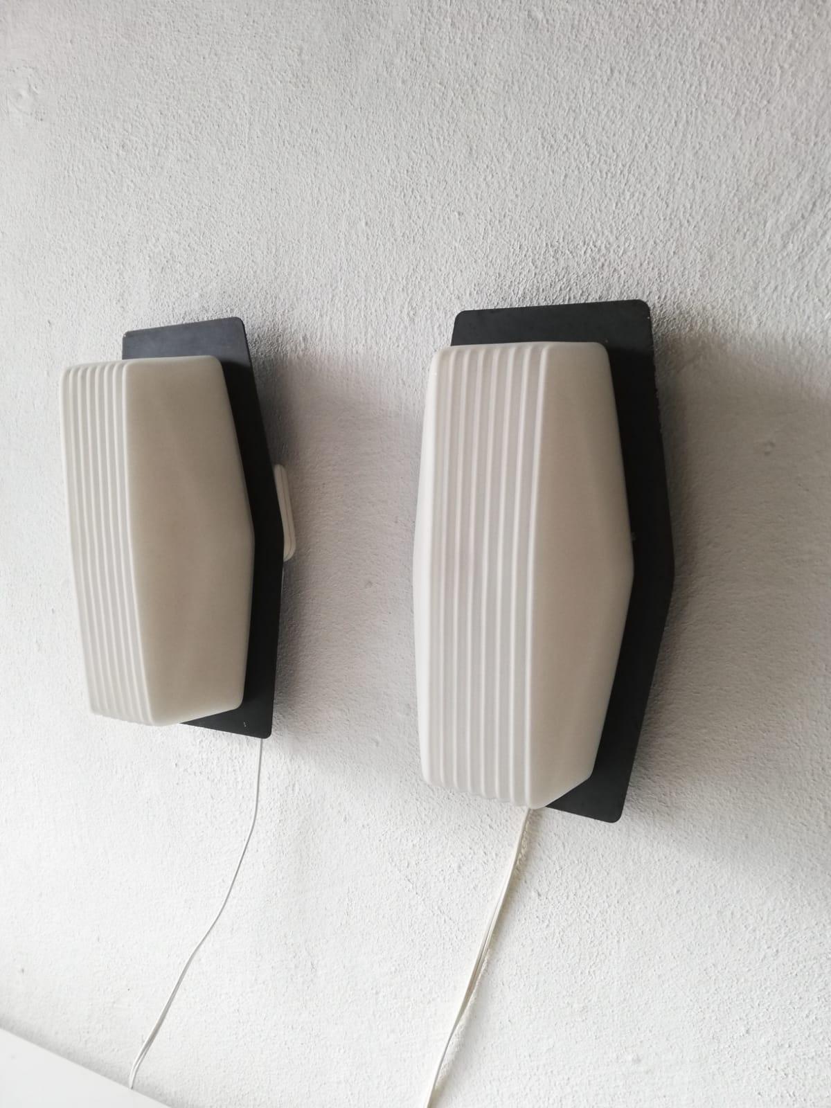 Textured opaline glass pair of sconces by BEGA, 1960s Germany

Rare and Minimalist wall lamps.

Lamps are in very good vintage condition.

These lamps works with E27 standard light bulbs. 
Wired and suitable to use in all countries. (110-220