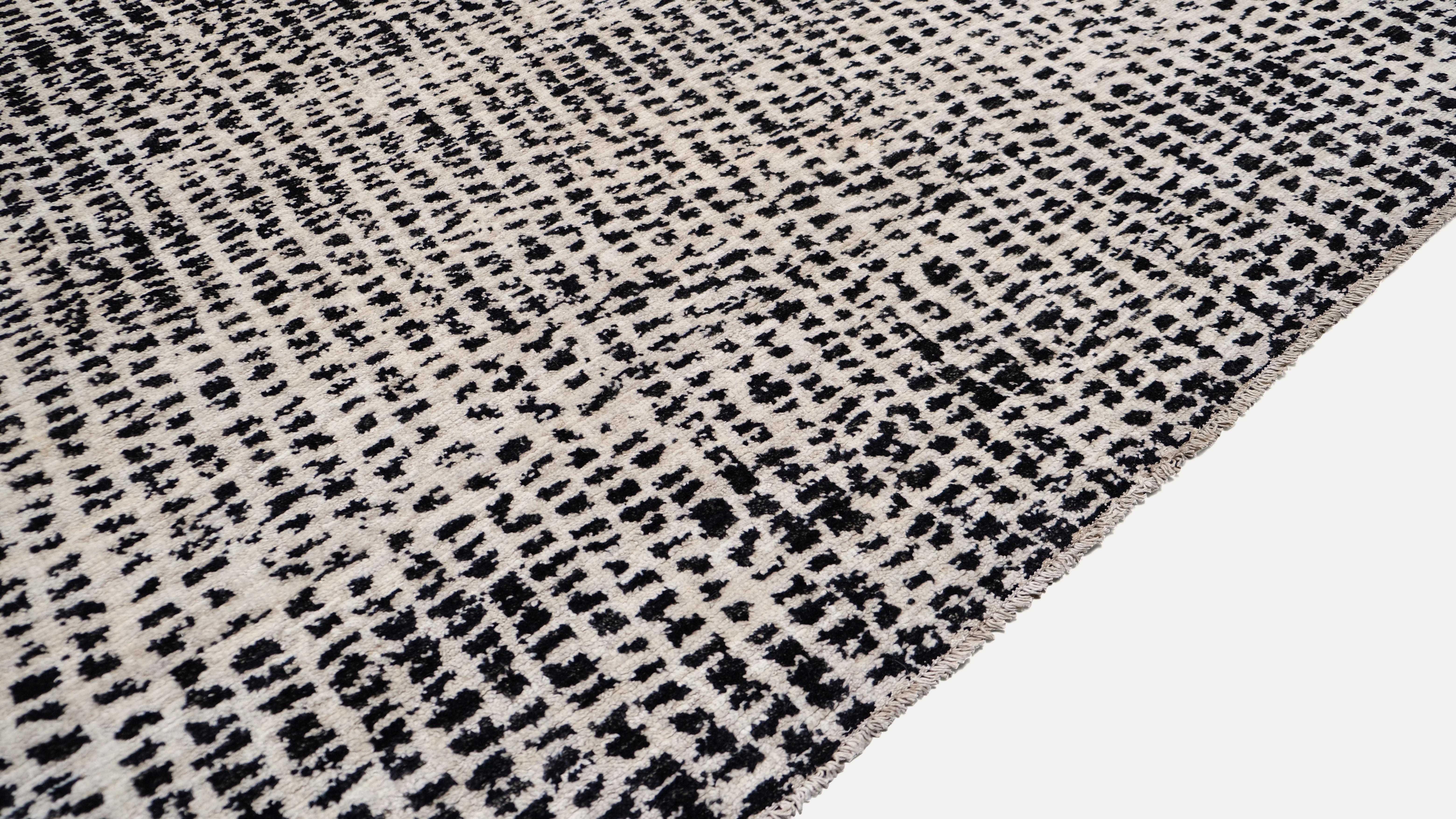 This hand-knotted wool rug embodies the essence of modern minimalism and contemporary design. Featuring a black and ivory textured pattern that mimics the subtle irregularities of hand-drawn lines and abstract textures, this rug creates a