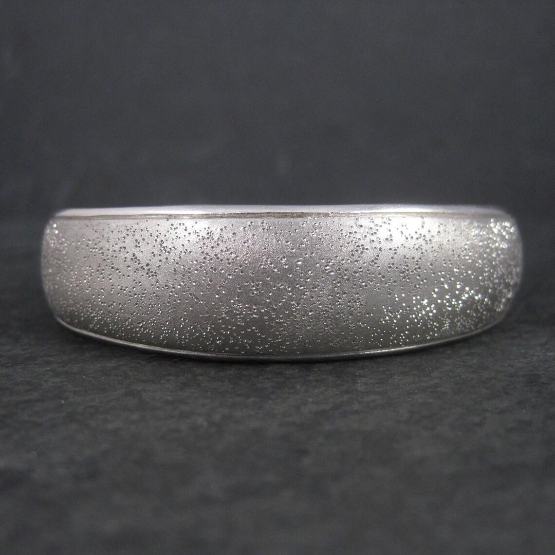 Questo bellissimo bracciale in sterling è una creazione del designer francese Charles Garnier.
Presenta la famosa texture scintillante che è diventata un'icona dei prodotti Garnier.

Nel punto più largo, questo bracciale misura 5/8 di pollice e 3/8