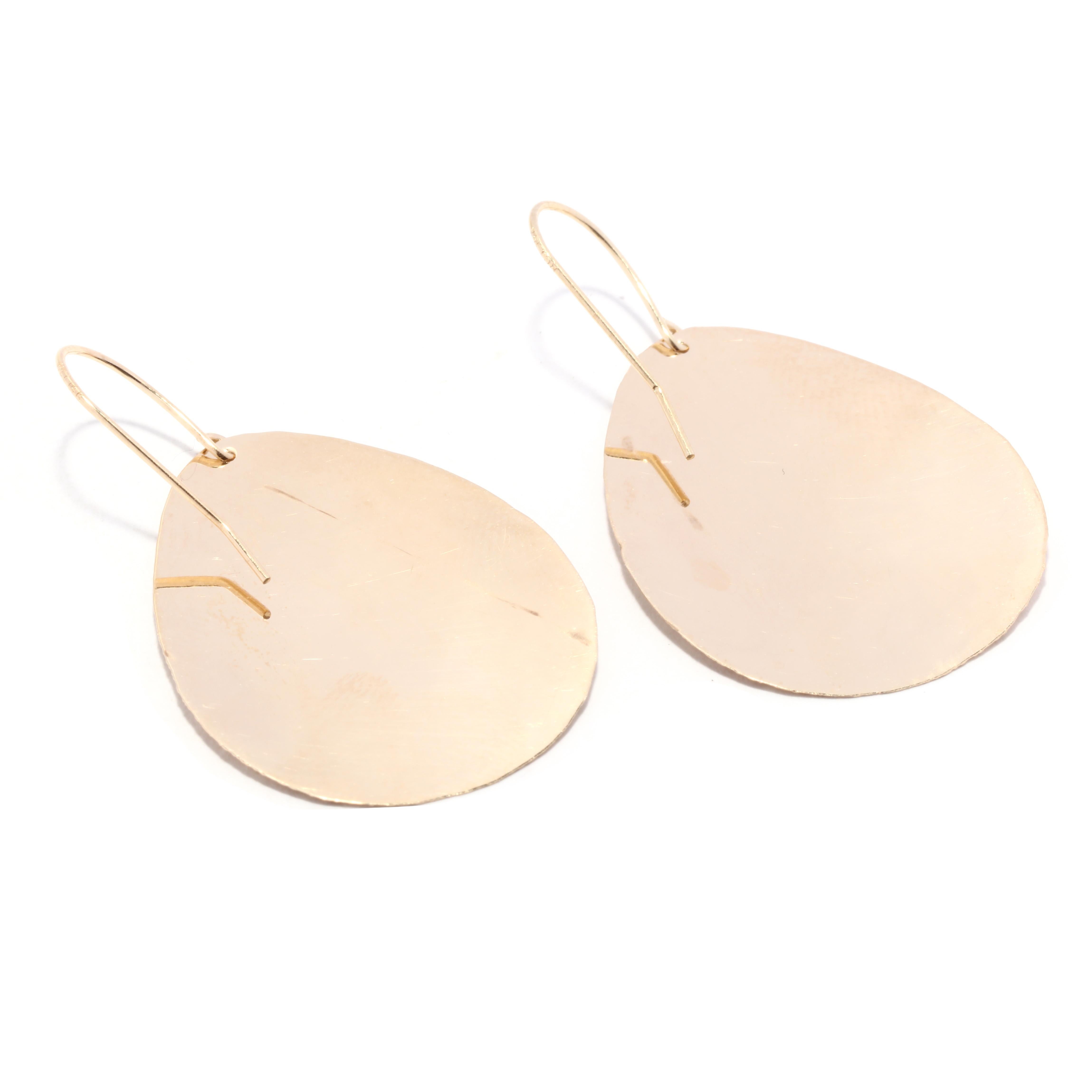A pair of 14 karat yellow gold textured teardrop dangle earrings. These simple drop earrings features a flat, slightly curved teardrop shape with an applied textured finish and with ear wires.

Length: 2 5/8 in.

Width: 7/8 in.

Weight: 2 dwts. /
