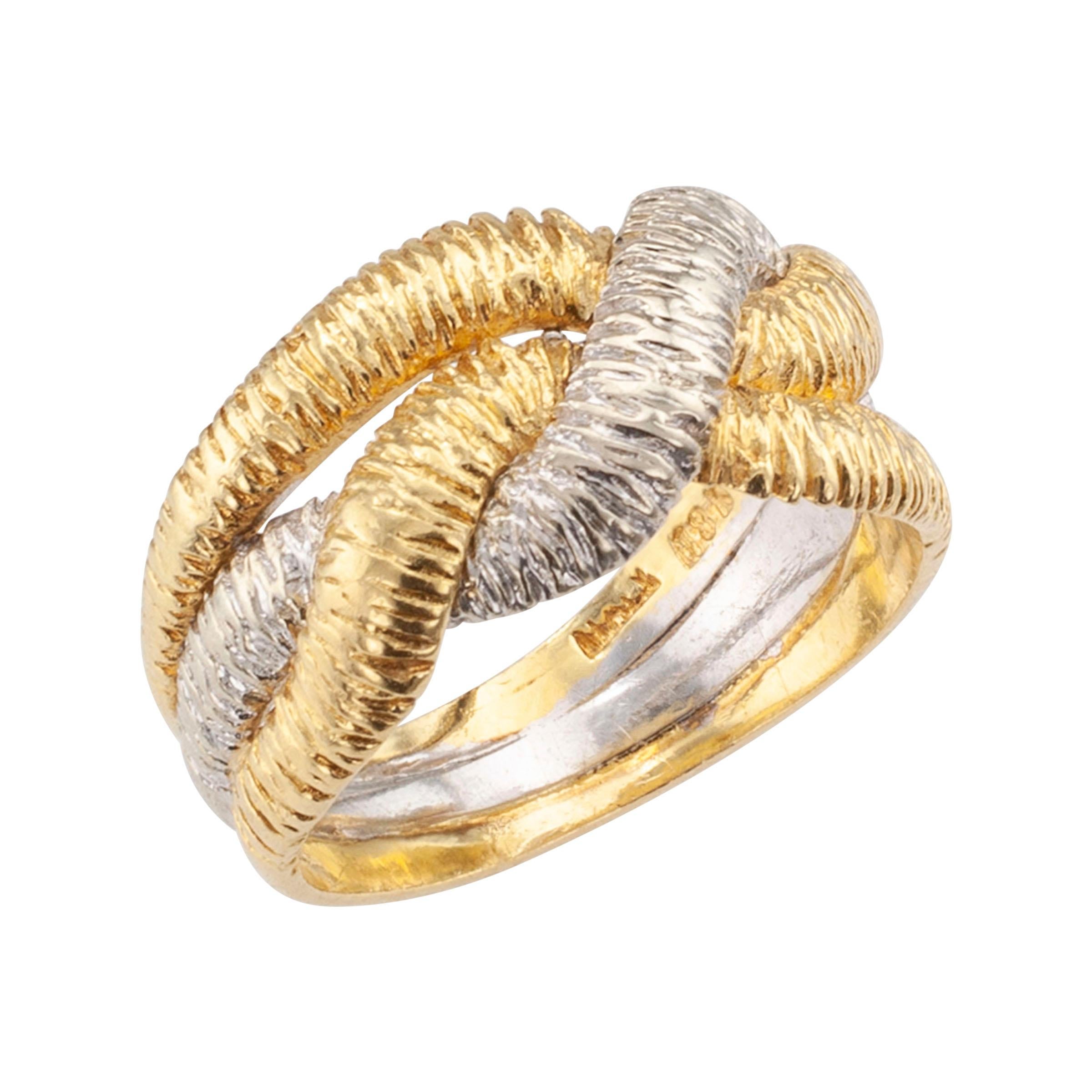 Textured two-tone gold ring band circa 1960 .

DETAILS: 
Entwined and textured two-tone gold ring band.
METAL: yellow and white 18-karat gold
RING SIZE: approximately 5 ½.
MEASUREMENTS: approximately 3/8” (10 mm) wide vertical to the fingernail.