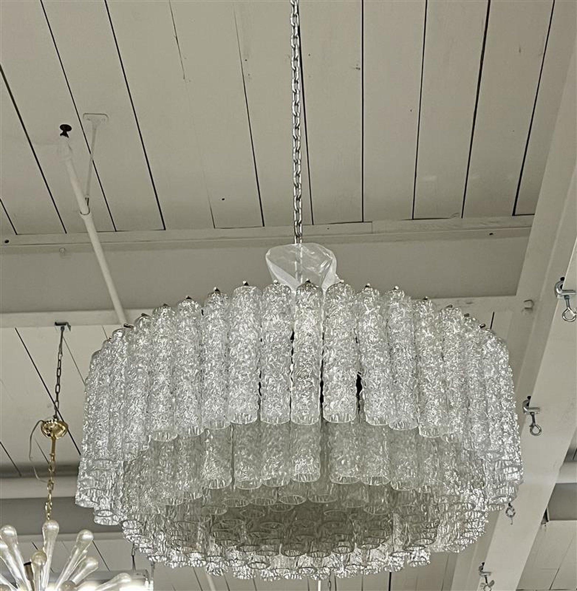 This is a beautiful rare Venini chandelier. It is vintage with hand blown textured Murano glass tubes. The height can be adjusted with the chain. This has not been UL approved. 

