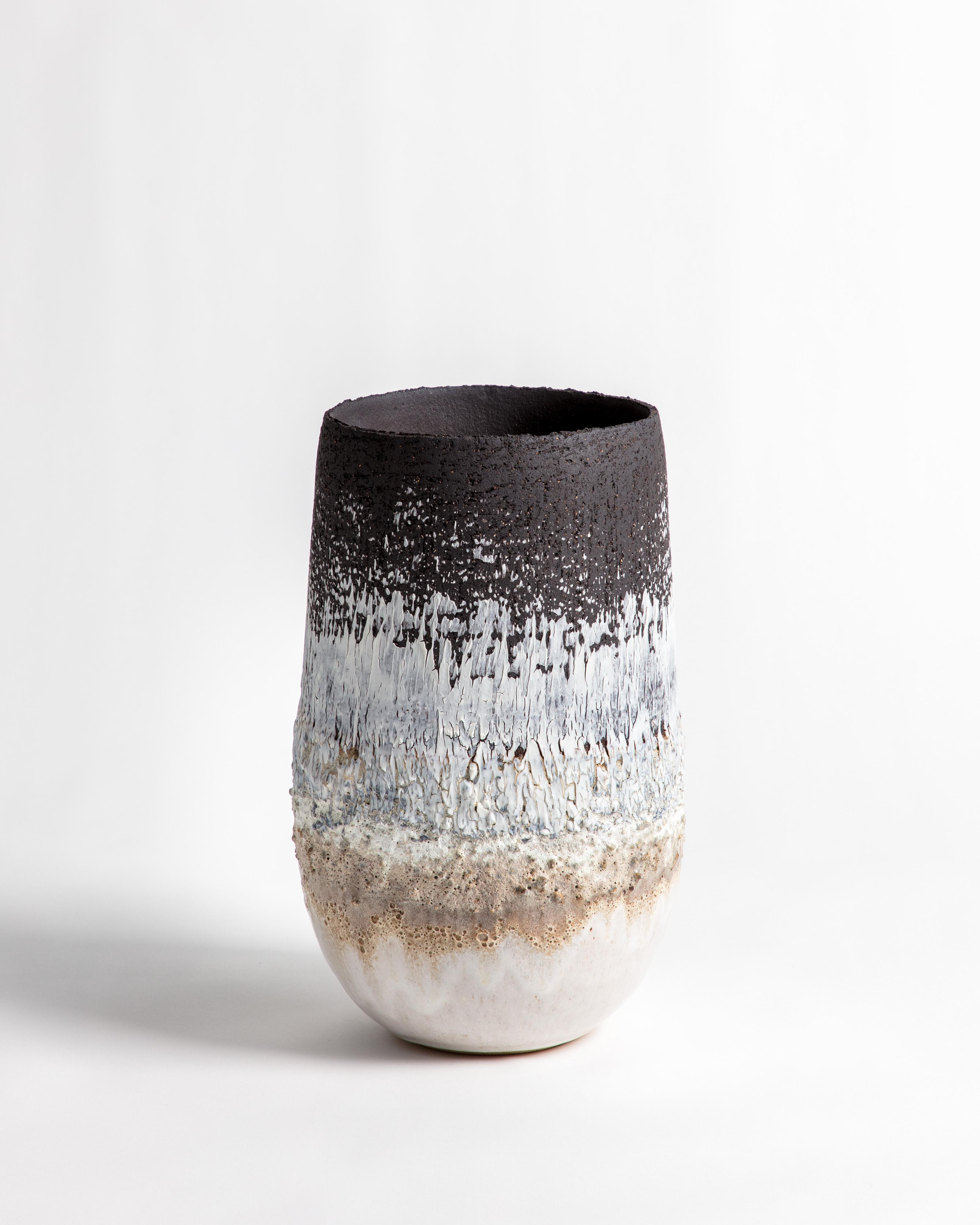 A heavily textured volcanic open shaped vessel with black and white glaze and markings. Made from black textured stoneware clay and porcelain engobe.

Inspiration for the piece comes from the clay itself and the chemical relationships that glaze and