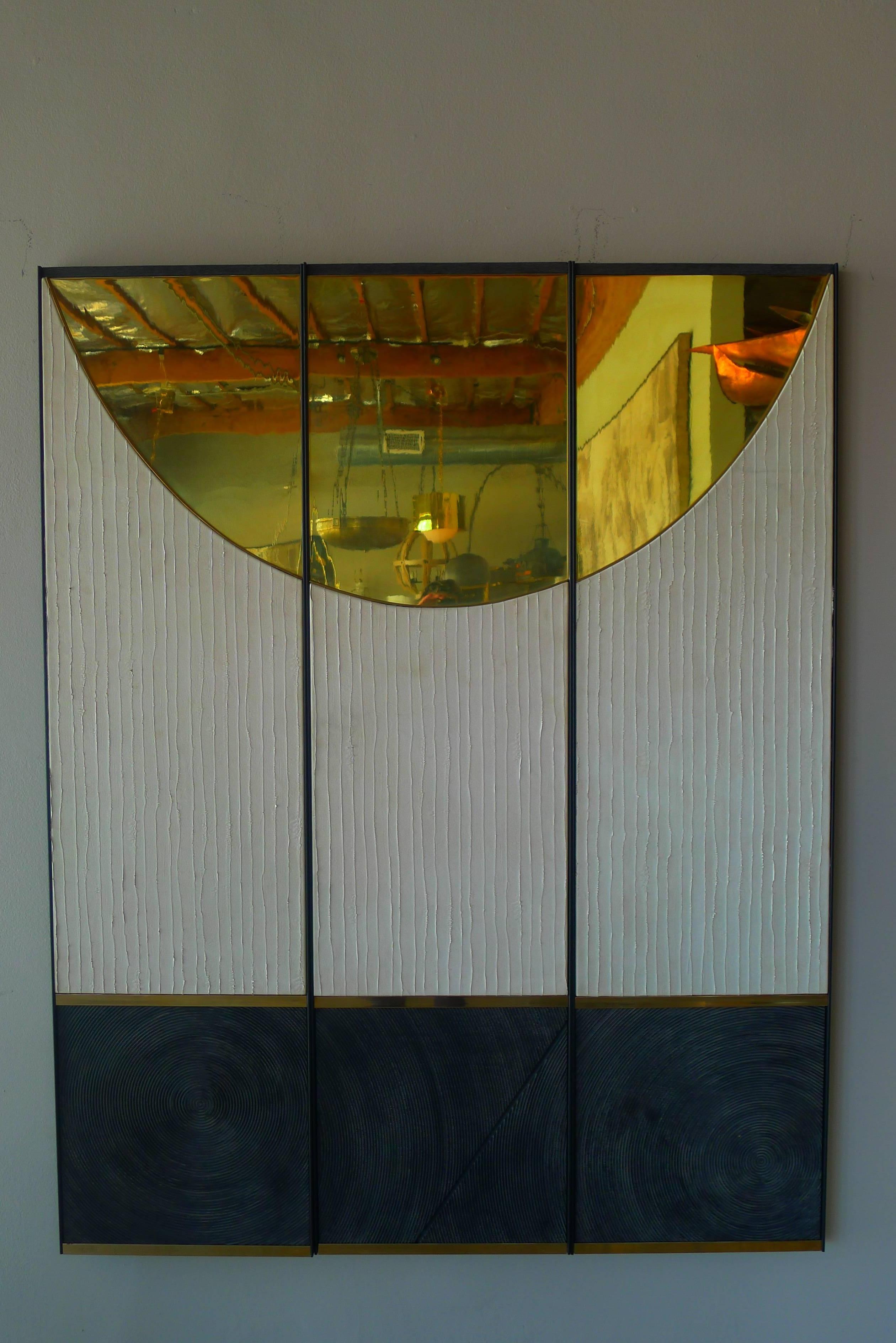 Triptych wall art panels by Paul Marra consisting of leather, brass, textured wood, steel frames. Shown hung as 49.5 W - each panel is 16.5 W. Brass has reflective qualities.