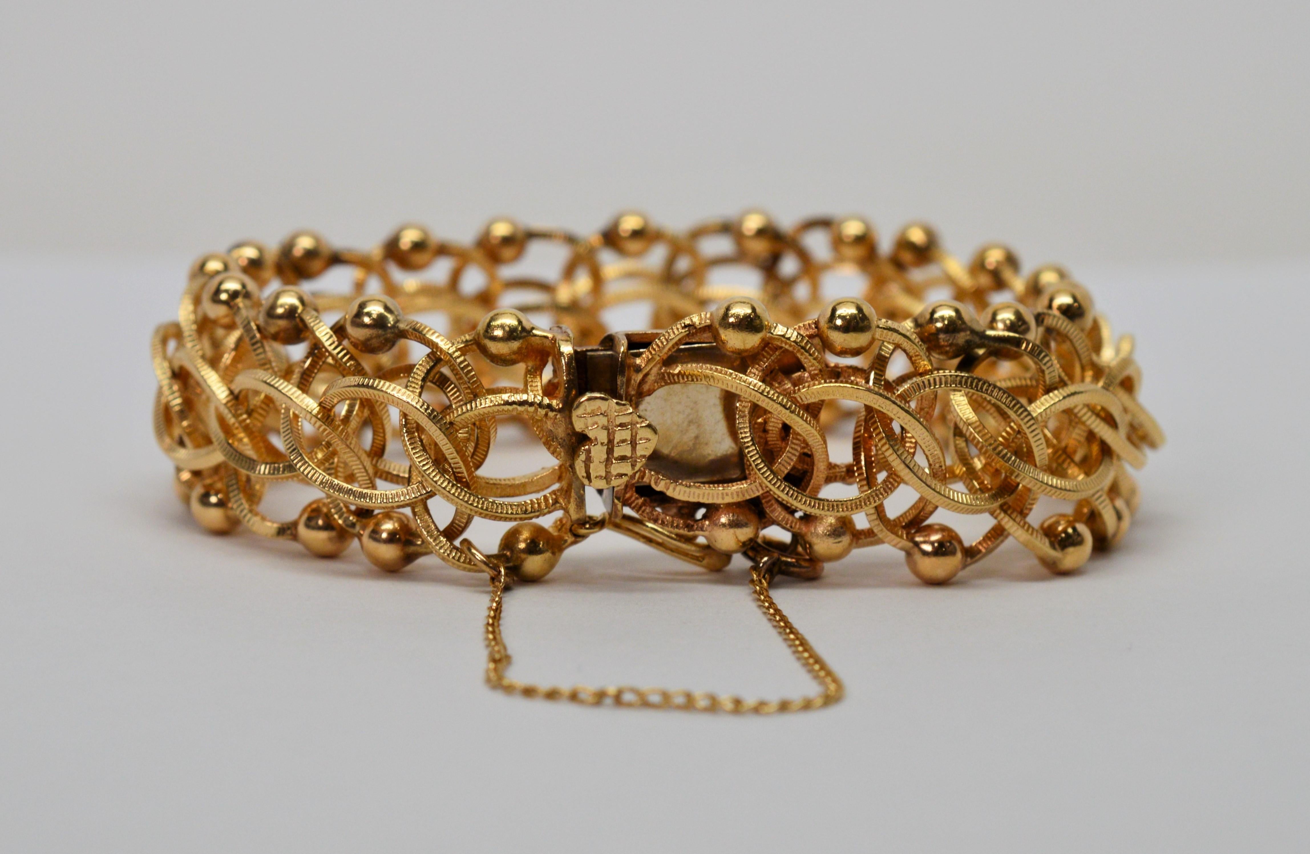Stunning, with added attention to detail describes this 1950s bracelet with the use of texture on the interwoven multiple fourteen carat yellow gold links that create a very attractive chain pattern.  Further highlighting the intricacy of the design