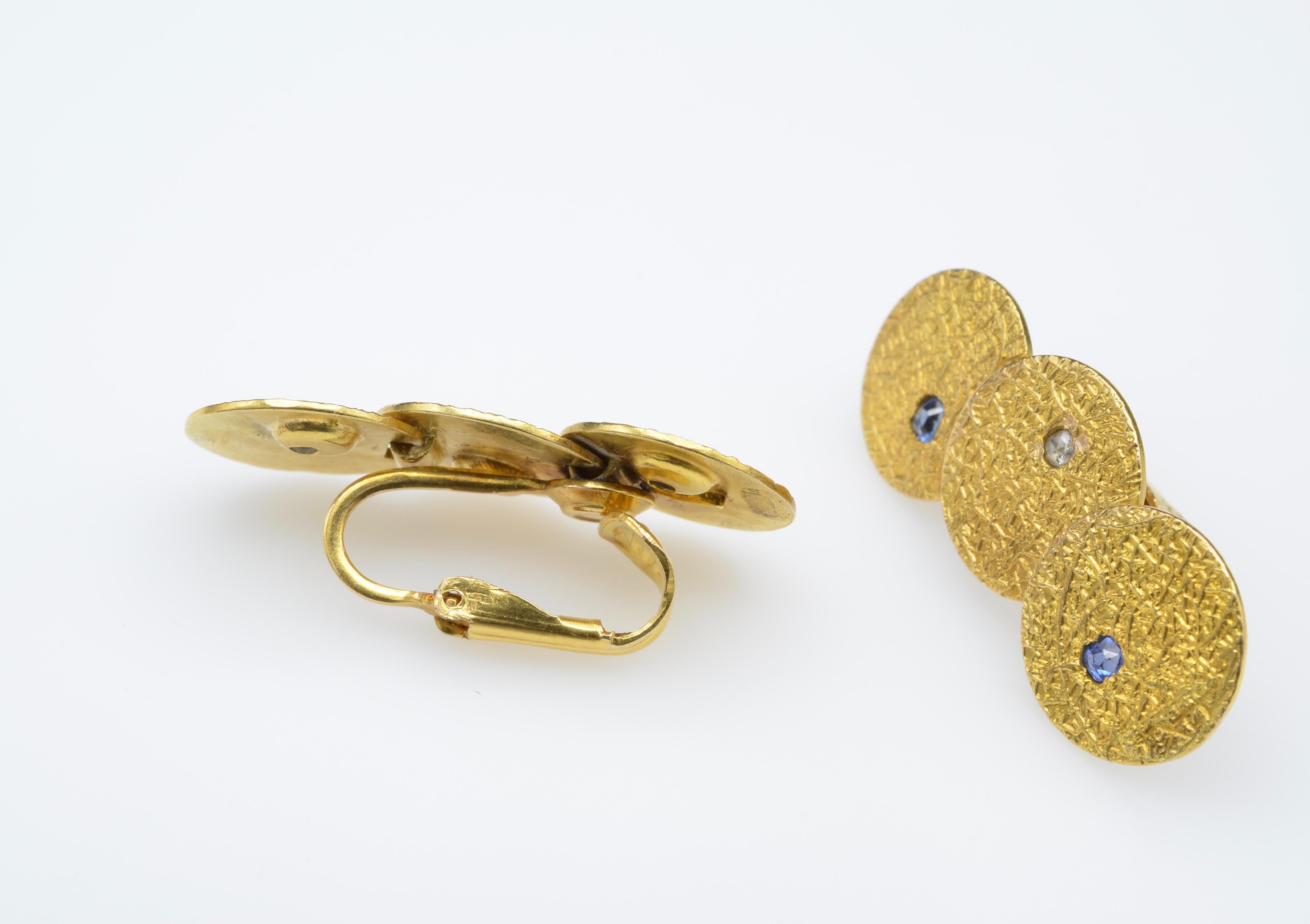 Radiant sapphires and diamonds dance upon these textured vintage disc clip-on earrings. We are happy to turn them into post earrings if you like. 18K yellow and 14K yellow gold glimmer and shine with cross-hatching texture and rose-cut stones.