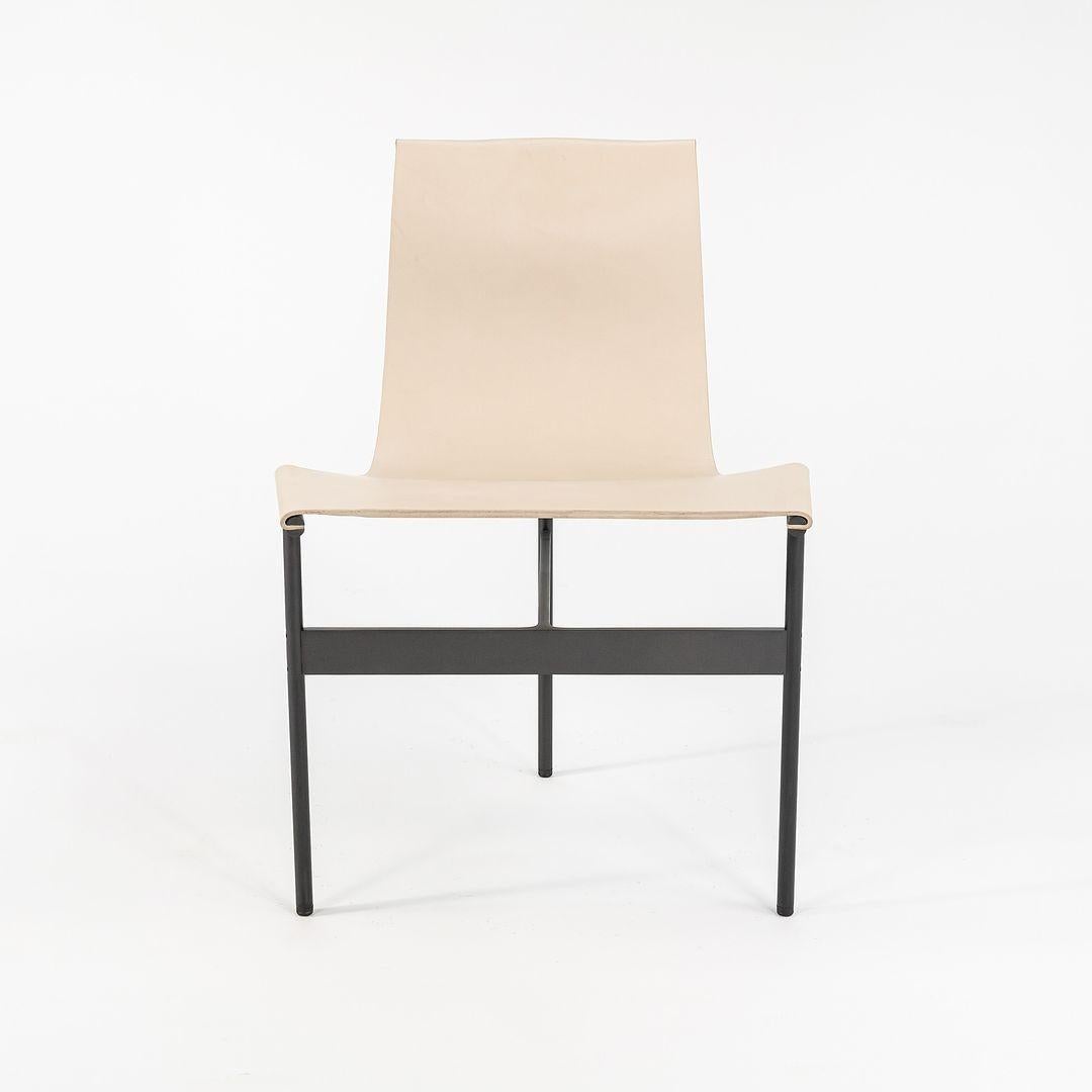 This is a TG-10 sling dining chair in Doral cream leather with a blackened frame, produced by Gratz Industries. The chair was designed by Katavolos, Littell and Kelley in 1952 as part of the original Laverne Collection produced by Gratz Industries,