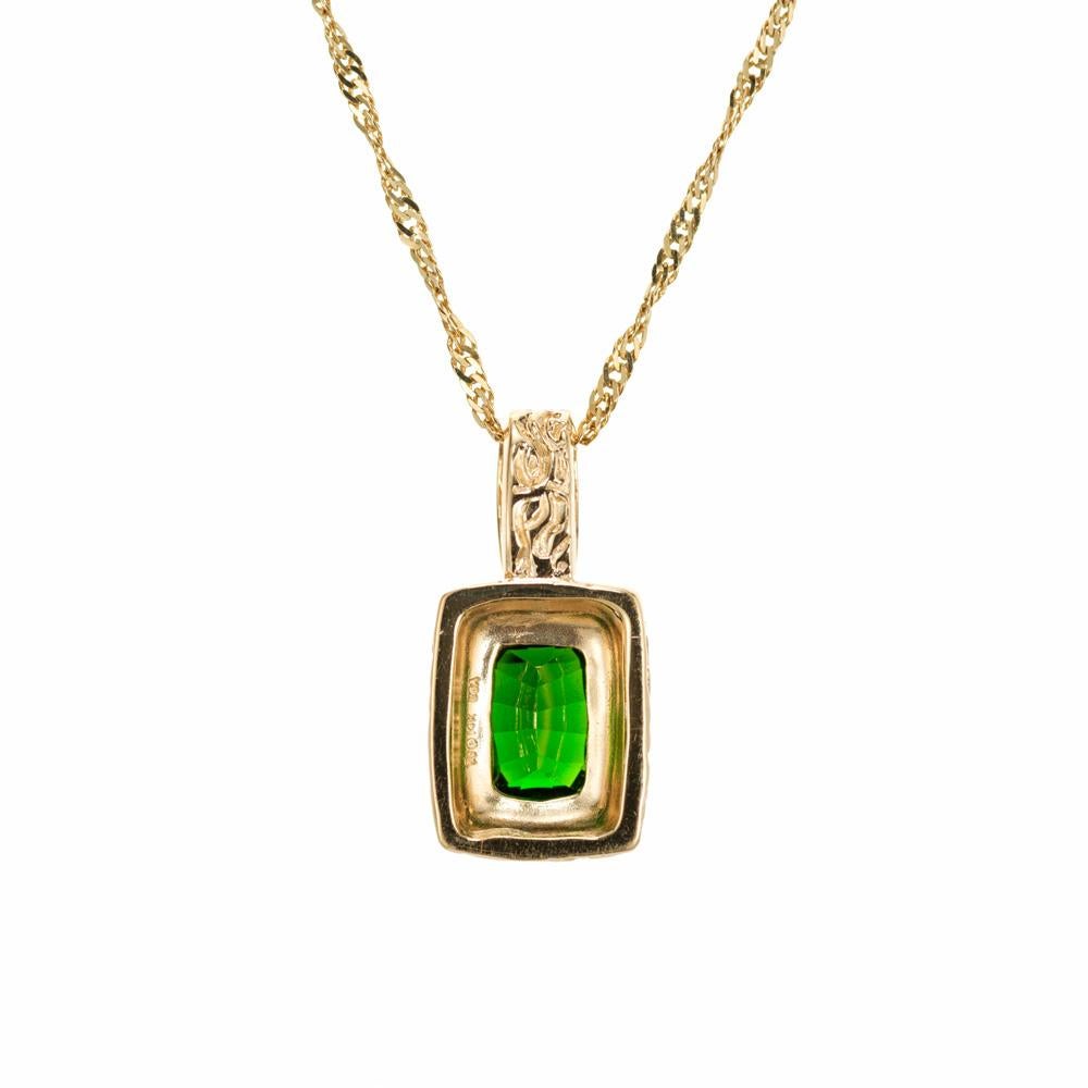 Bright green tourmaline pendant necklace . 2.25ct cushion shaped green tourmaline set in 14k yellow gold engraved pendant with a 16 inch 14k yellow gold chain. 

1 green cushion cut tourmaline, approx. 2.25cts
14k yellow gold 
Stamped: 14k
Hallmark: