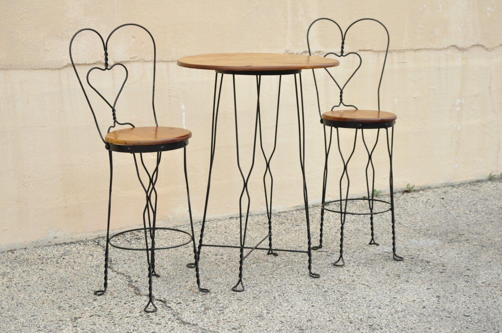 Vintage Ice Cream Parlor Bistro Dining Set Tall Table & Chairs Victorian Style - 3pc Set. Item features (1) round bistro dining table, (2) stools, wrought iron frame, wooden table top and seats, great style and form. Circa Mid to late 20th