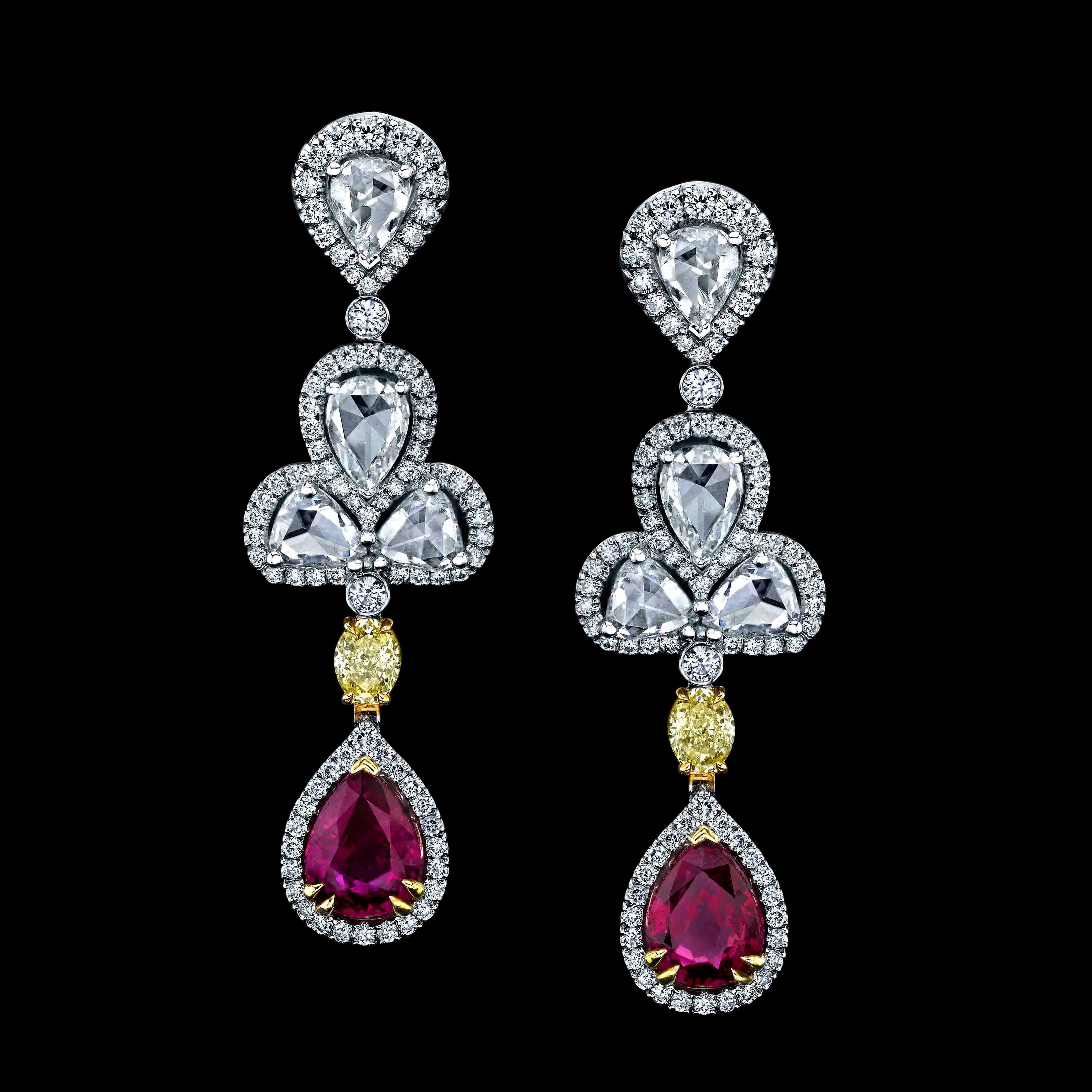 A beautiful pair of Extraordinary Ruby & Fancy Yellow Diamond Drop Earrings, set with a pair of Pear-shaped Pinkish Red Rubies weighing 2.77cts and certified by TGL. The rubies are styled with Fancy Yellow ovals, collection color rose-cuts, and pave